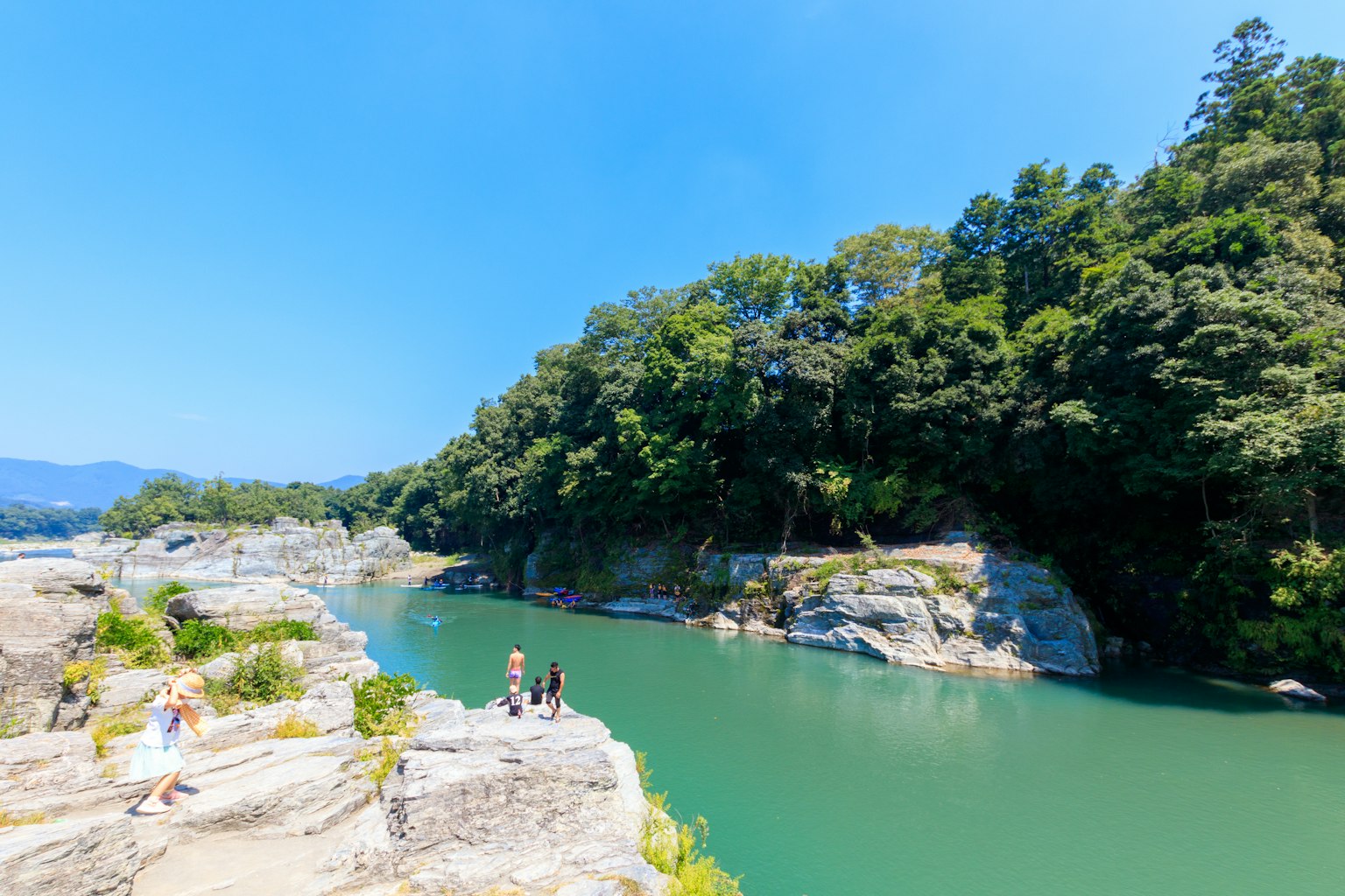 Vista panoramica di un fiume verde con rive rocciose sotto un cielo blu