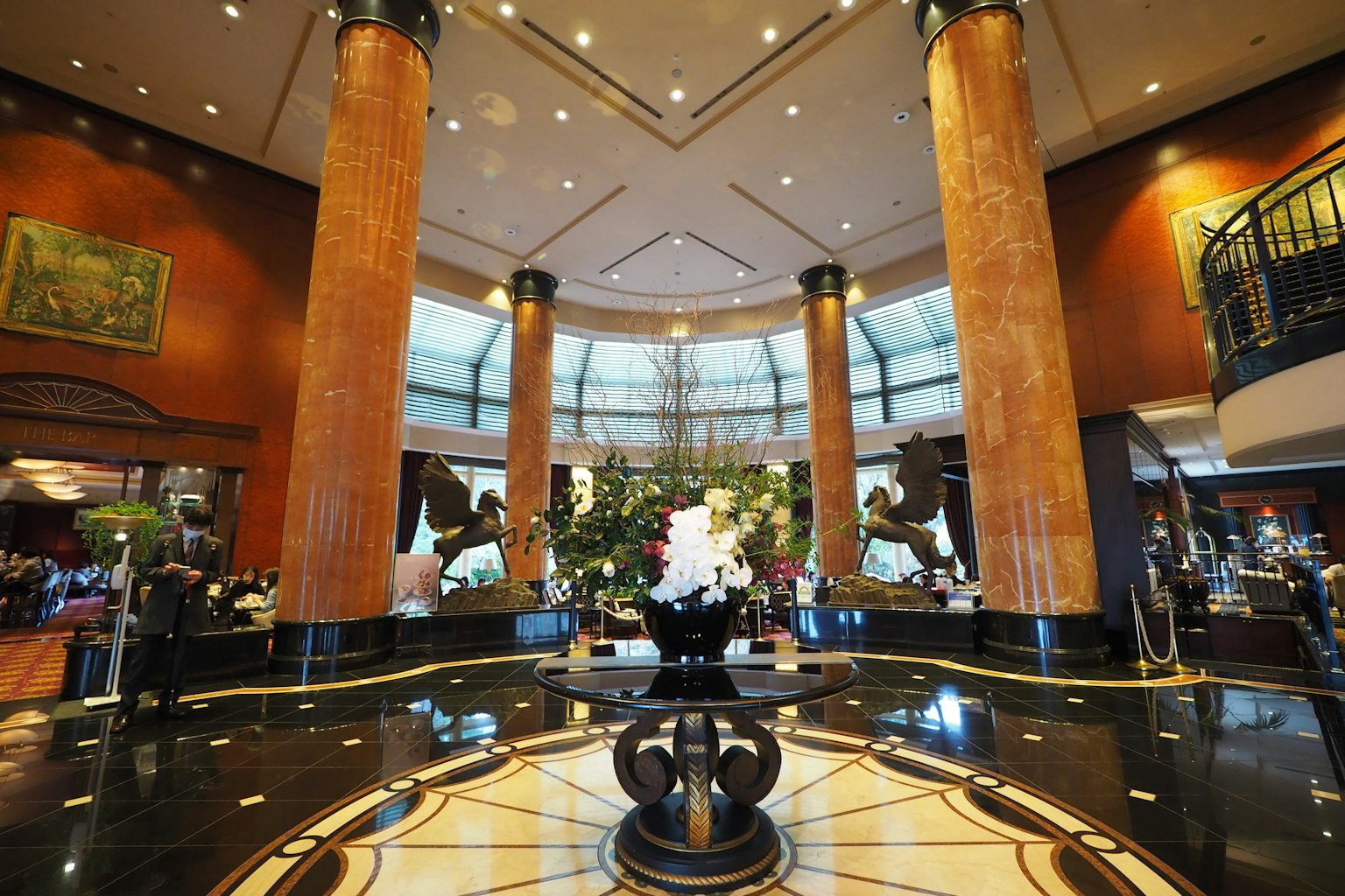 Luxurious hotel lobby featuring a marble fountain and tall columns