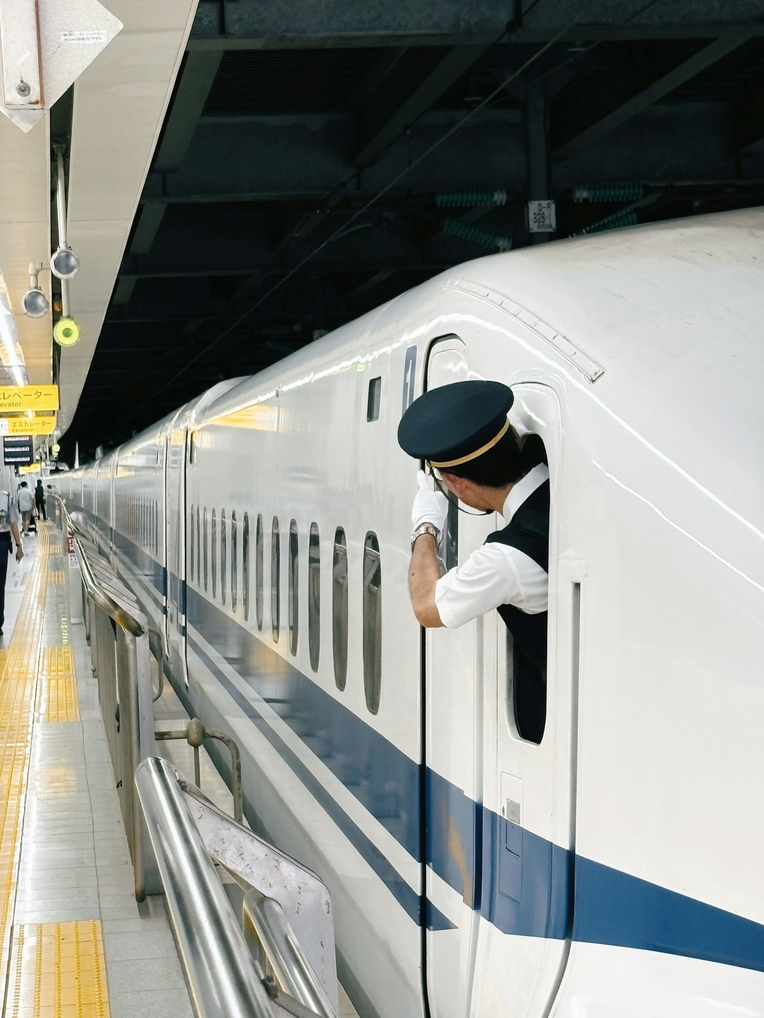 新幹線の運転手が窓から外を見ている駅の風景