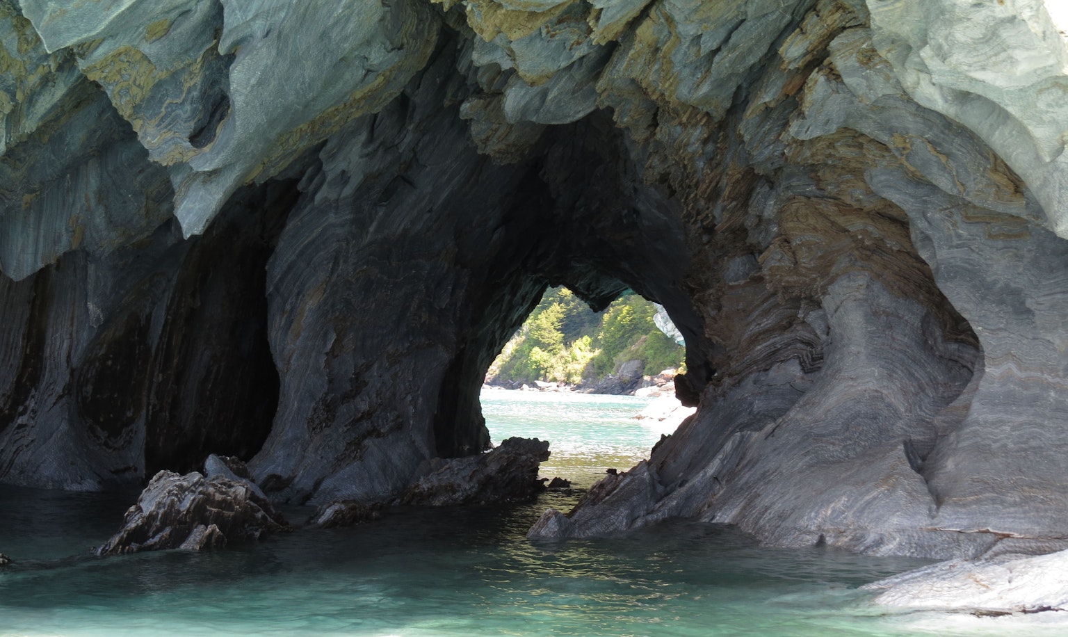 Túnel de roca rodeado de agua azul