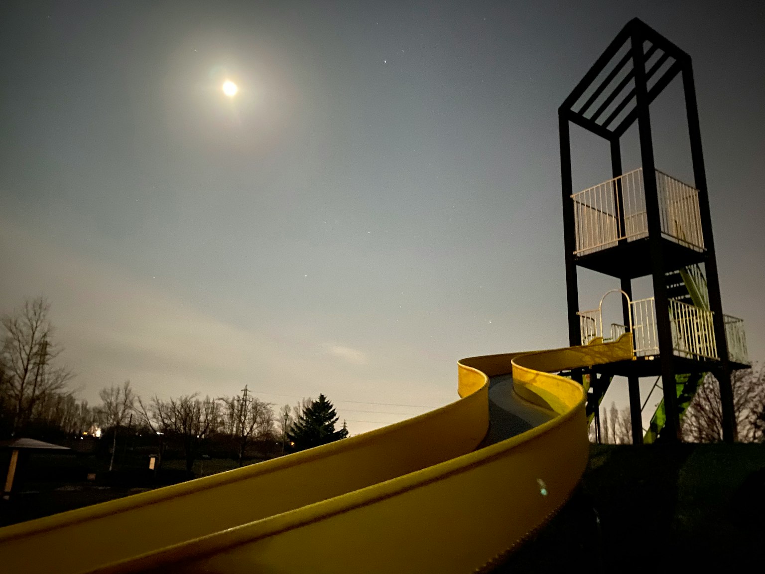 Scivolo giallo sotto il cielo illuminato dalla luna con una struttura a torre