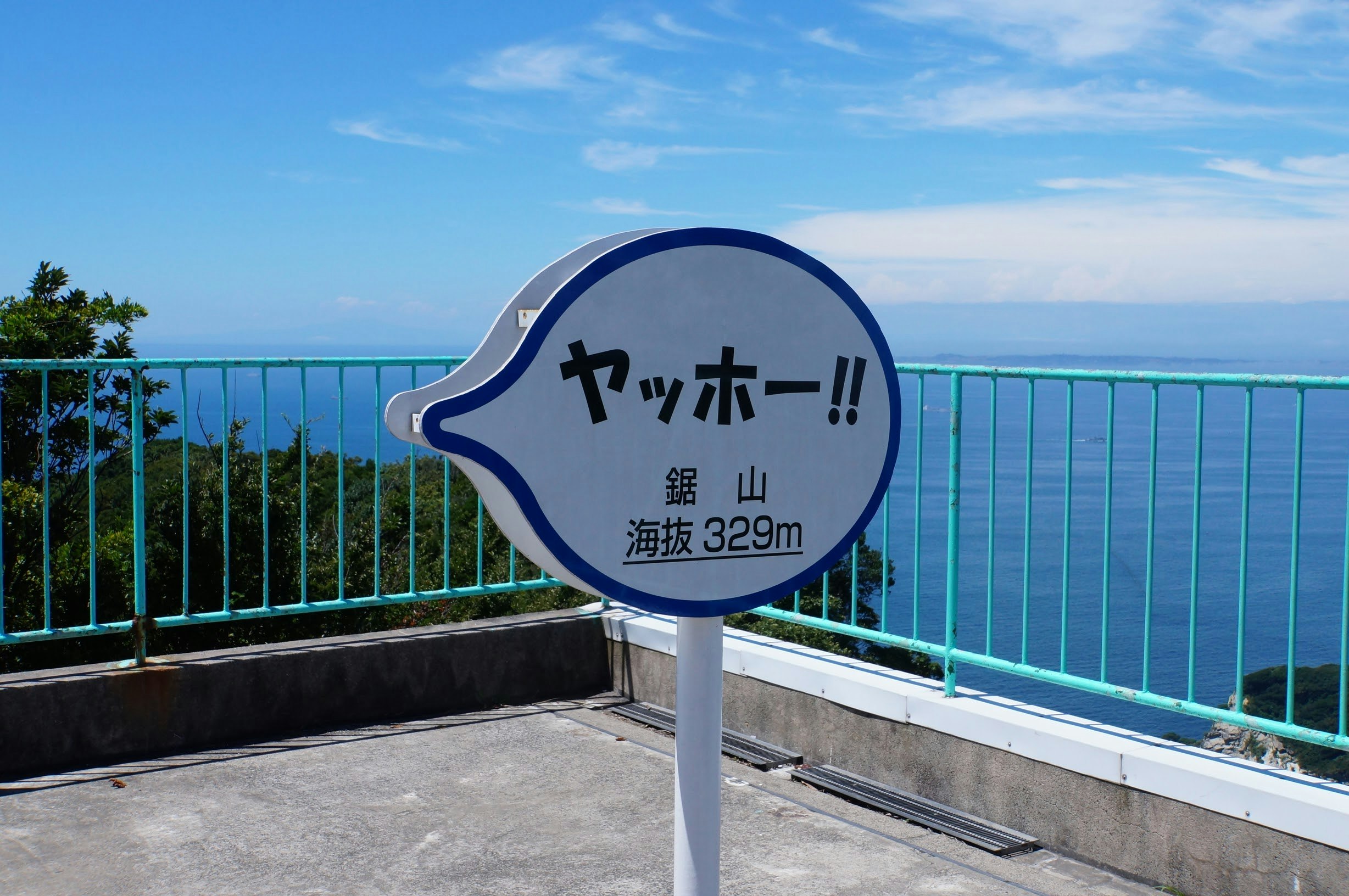 cartel “Yasshoo!!” en una terraza de observación junto al mar