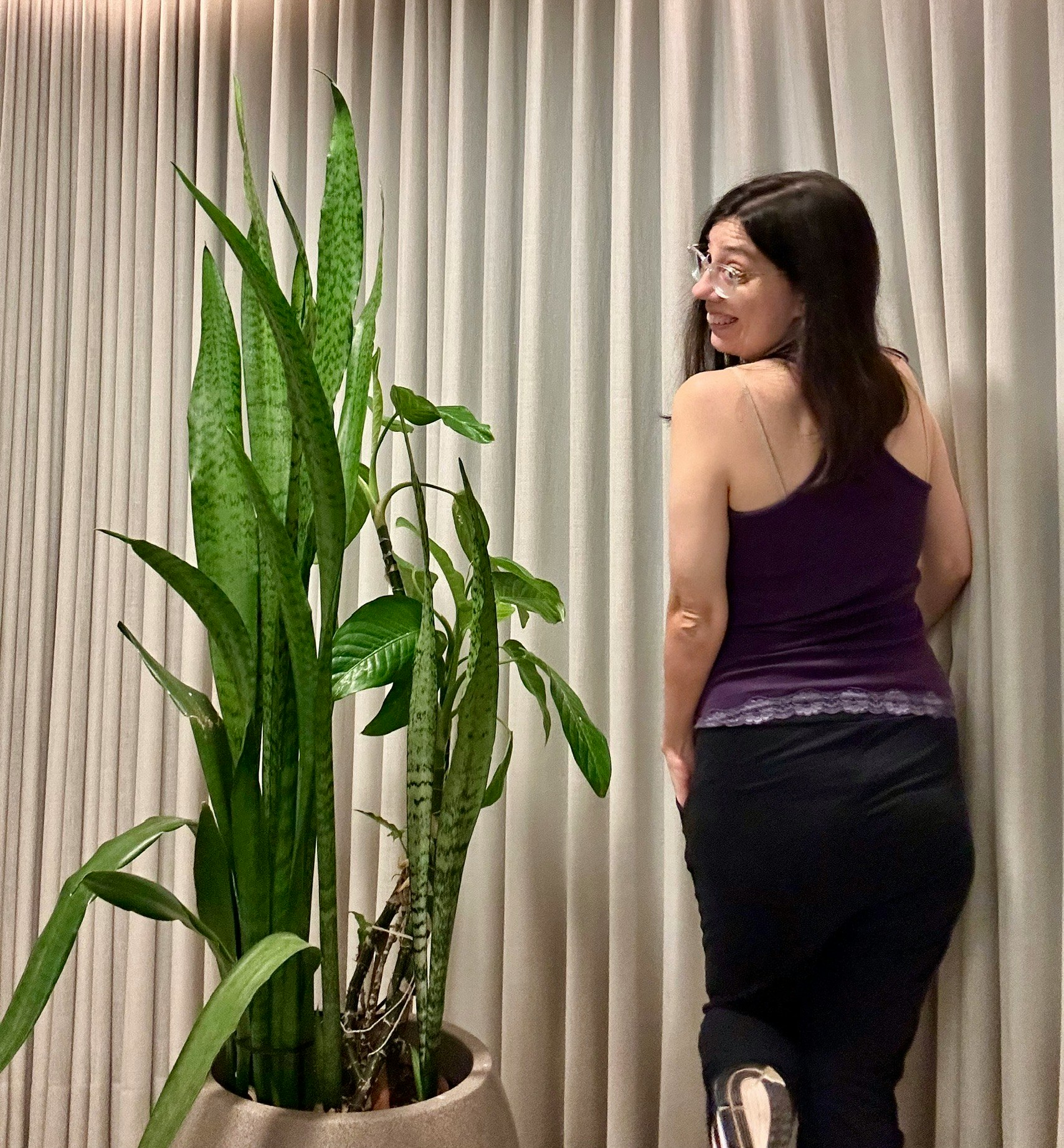 観葉植物のそばに立つ女性