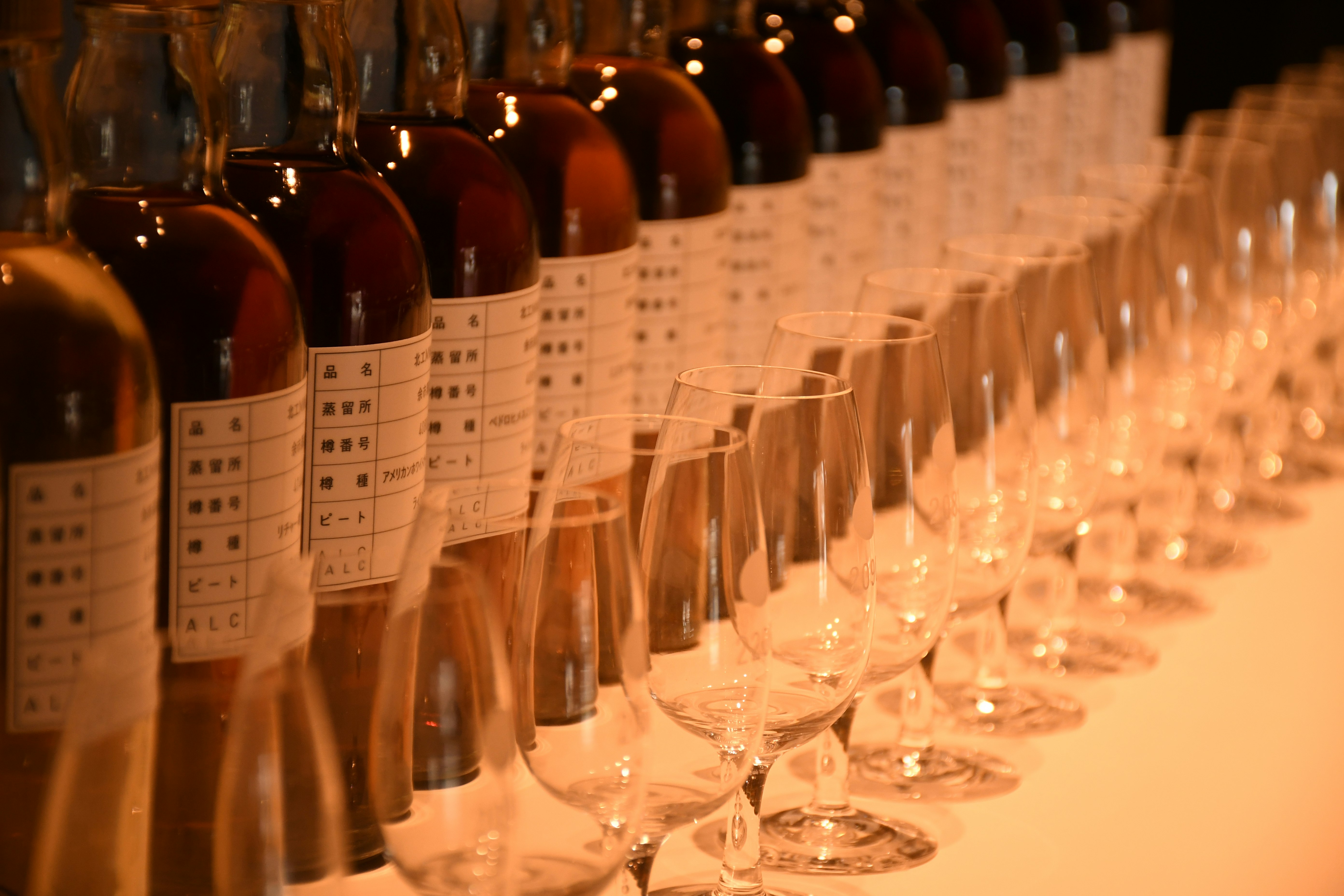 夜晚宴會桌上成排的酒瓶與酒杯