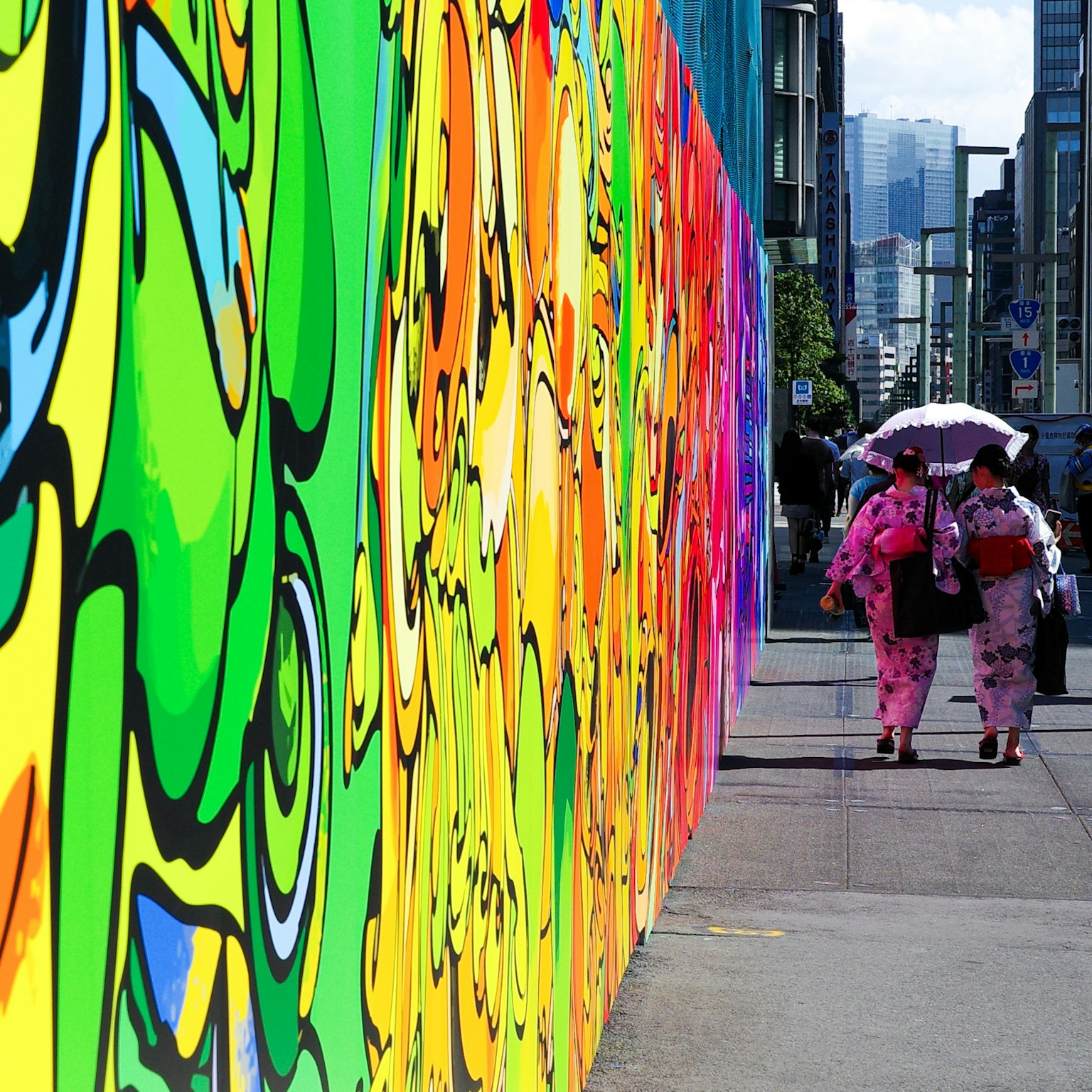 色彩斑斓的涂鸦墙和两位穿着和服的女性在街上走