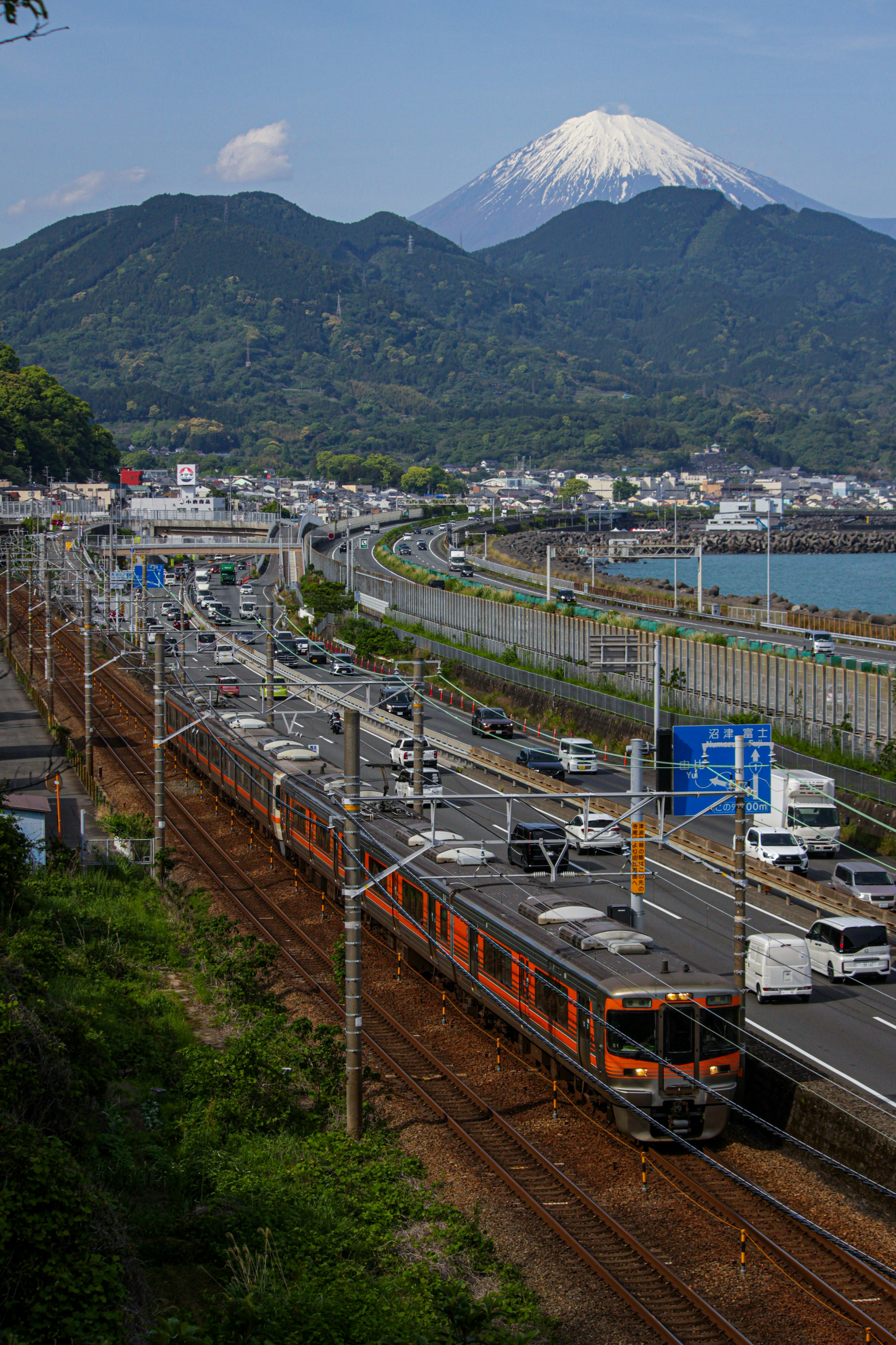 Trains running along coastal tracks with Mount Fuji in view