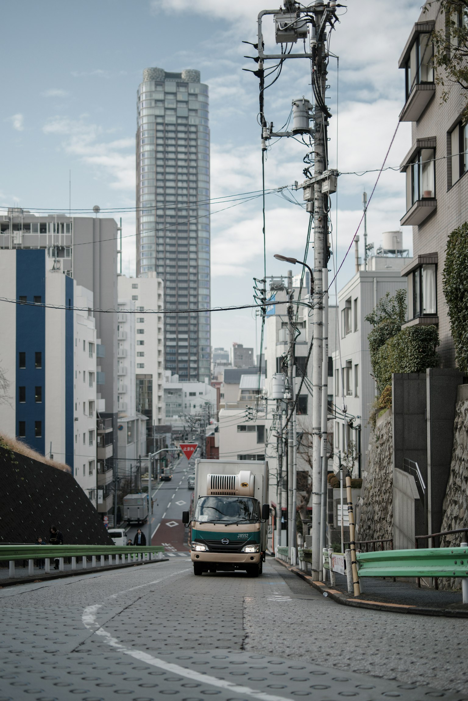 Furgone che percorre una strada tortuosa in un paesaggio urbano di Tokyo
