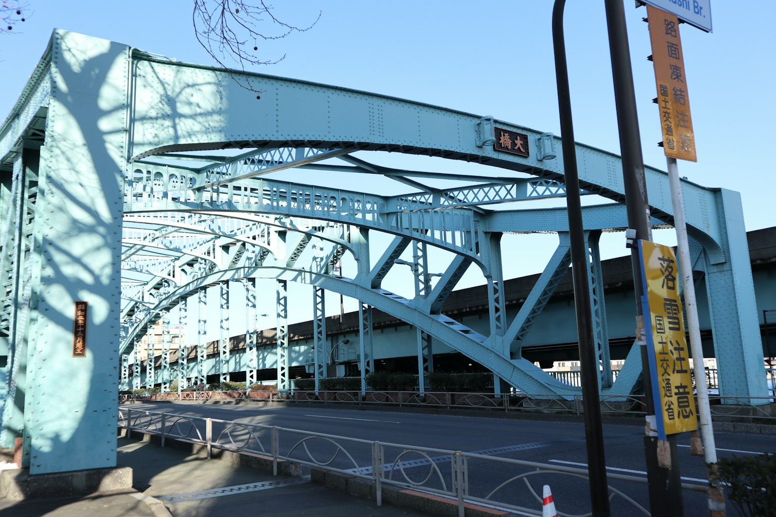 Ansicht einer blauen Bogenbrücke mit Stahlstruktur