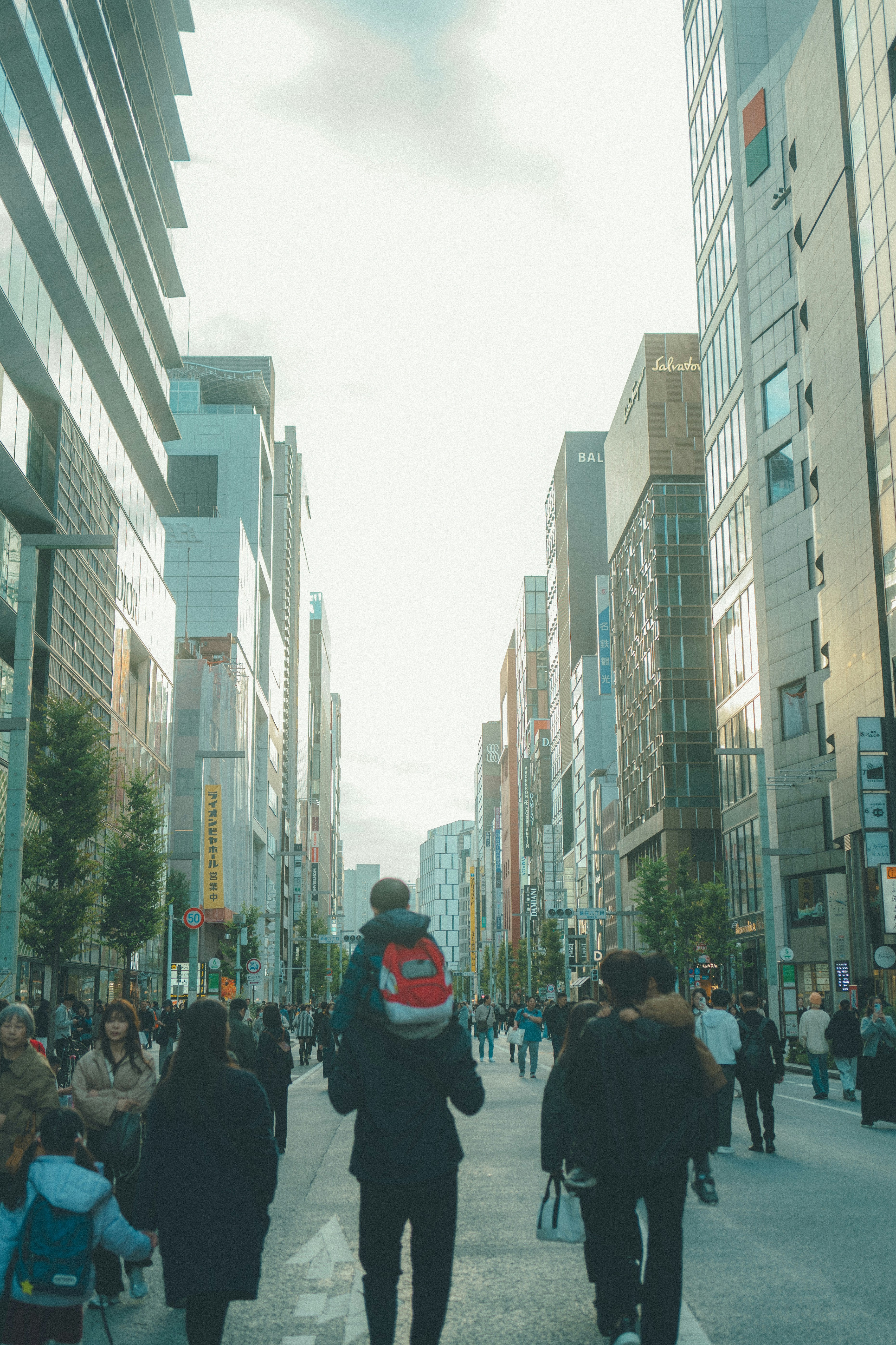 strada urbana con persone che camminano tra alti edifici