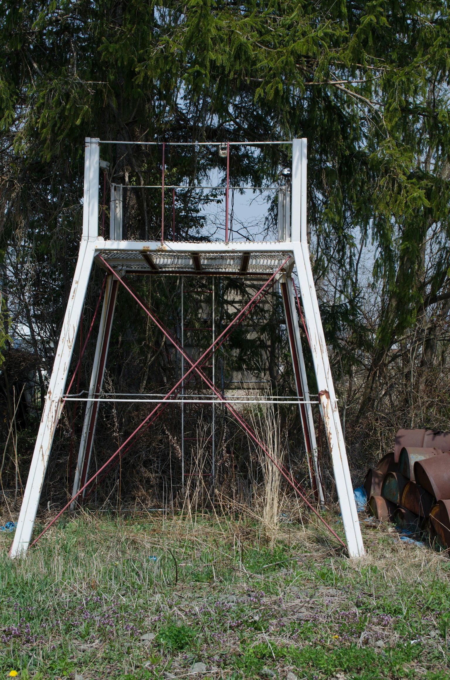 Un vecchio ponteggio in acciaio bianco in piedi in un'area erbosa