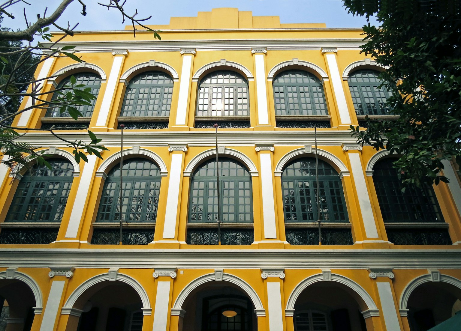Edificio storico con esterno giallo e grandi finestre ad arco