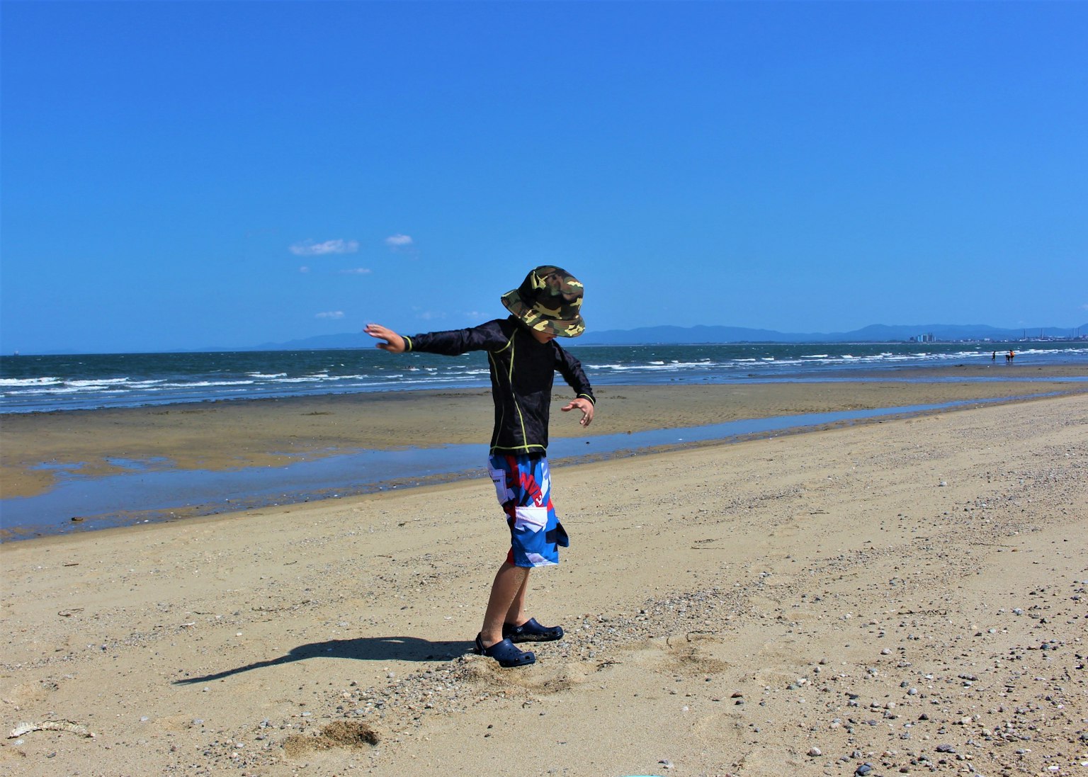 海滩上玩耍的男孩 蓝天和海浪