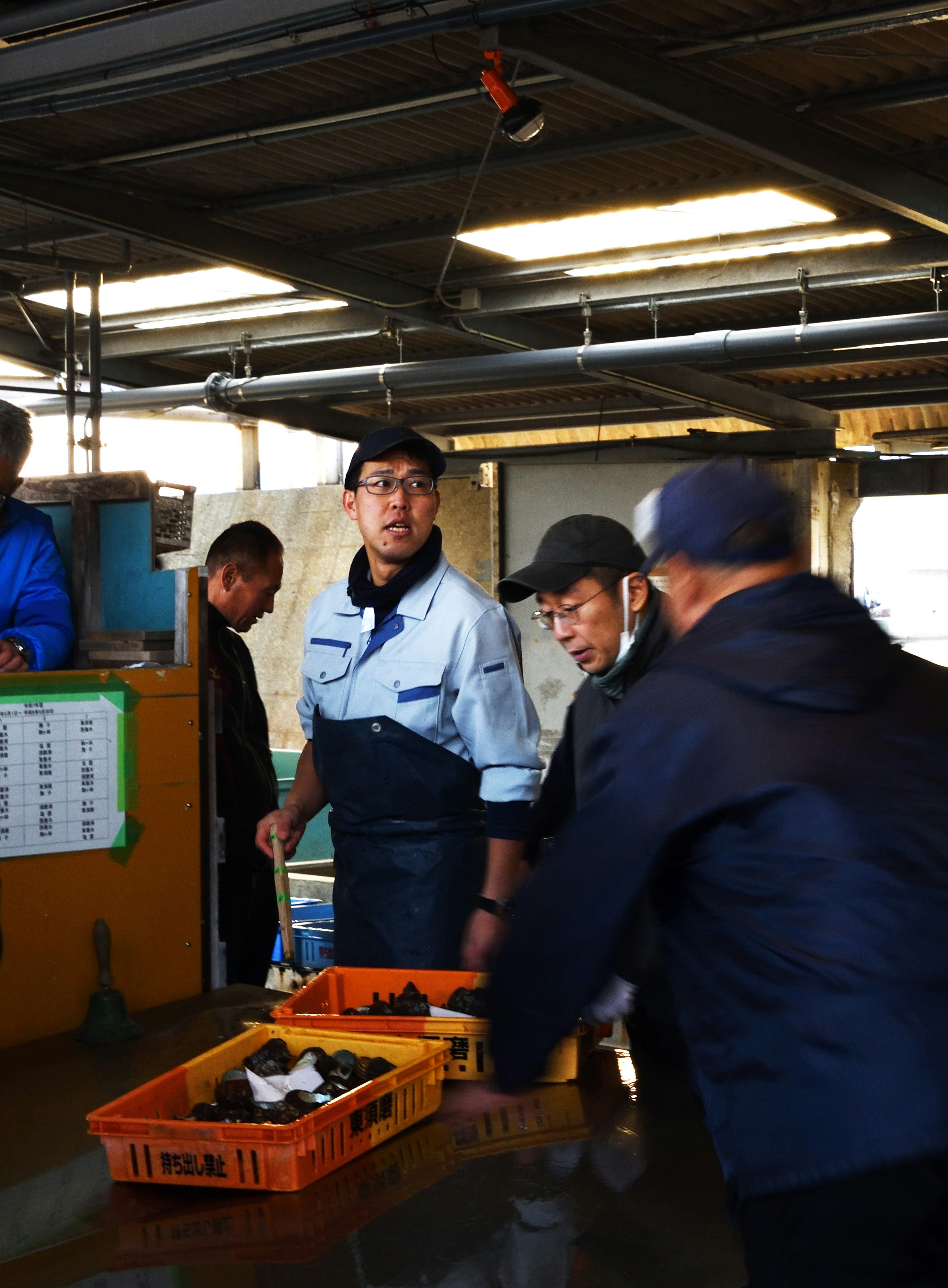 市場で働く人々が魚を扱っている様子