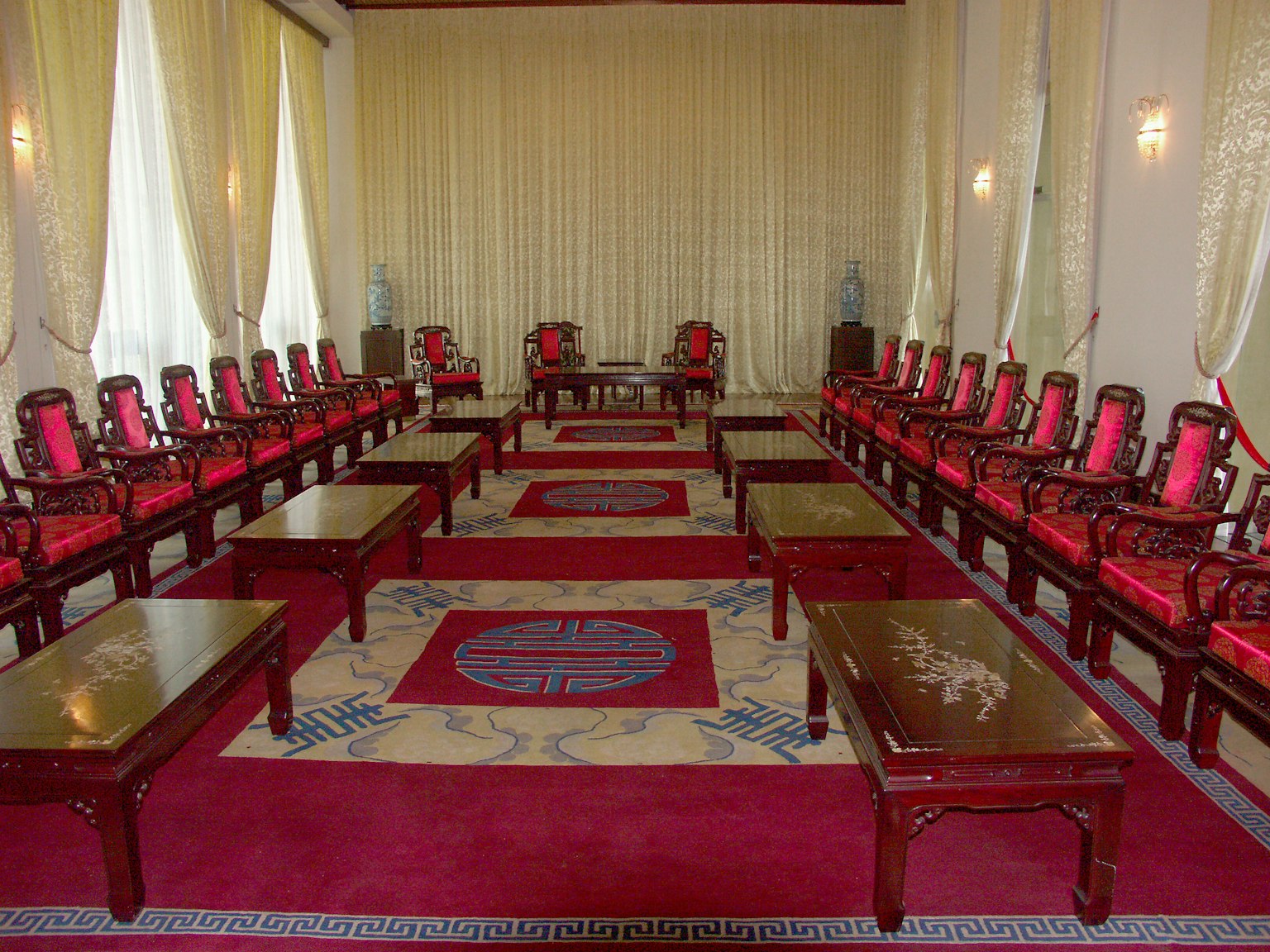 Interior ruangan mewah dengan kursi dan meja merah yang tertata rapi