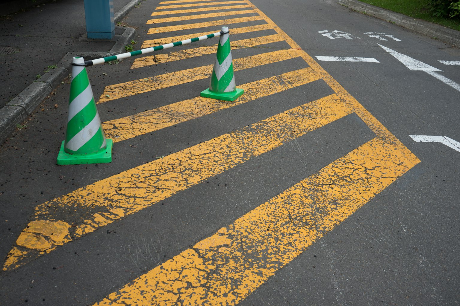 Scène d'une route avec un passage piéton jaune et des cônes de circulation verts