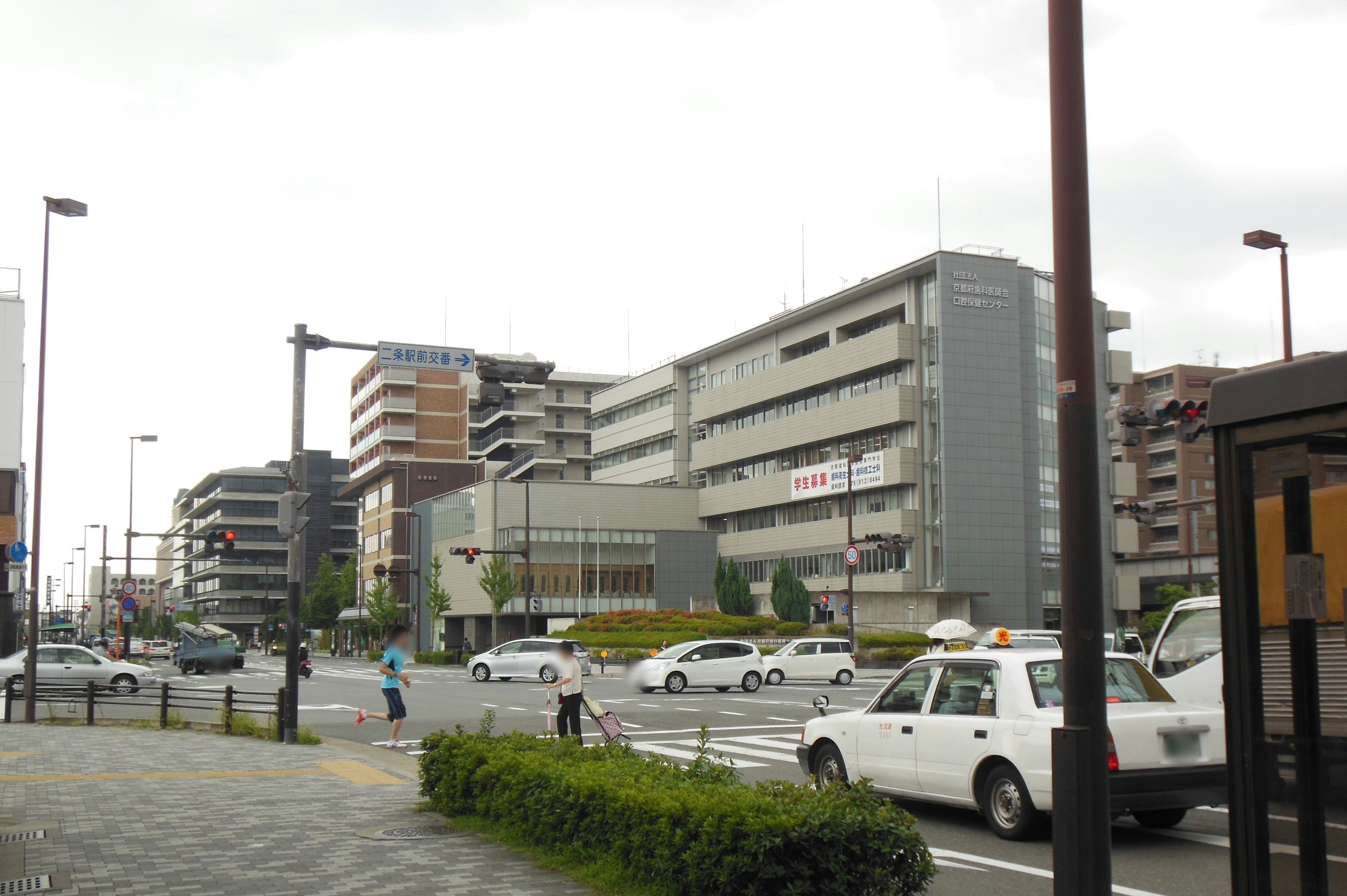 幹線道路沿いのビル群と車のある街角