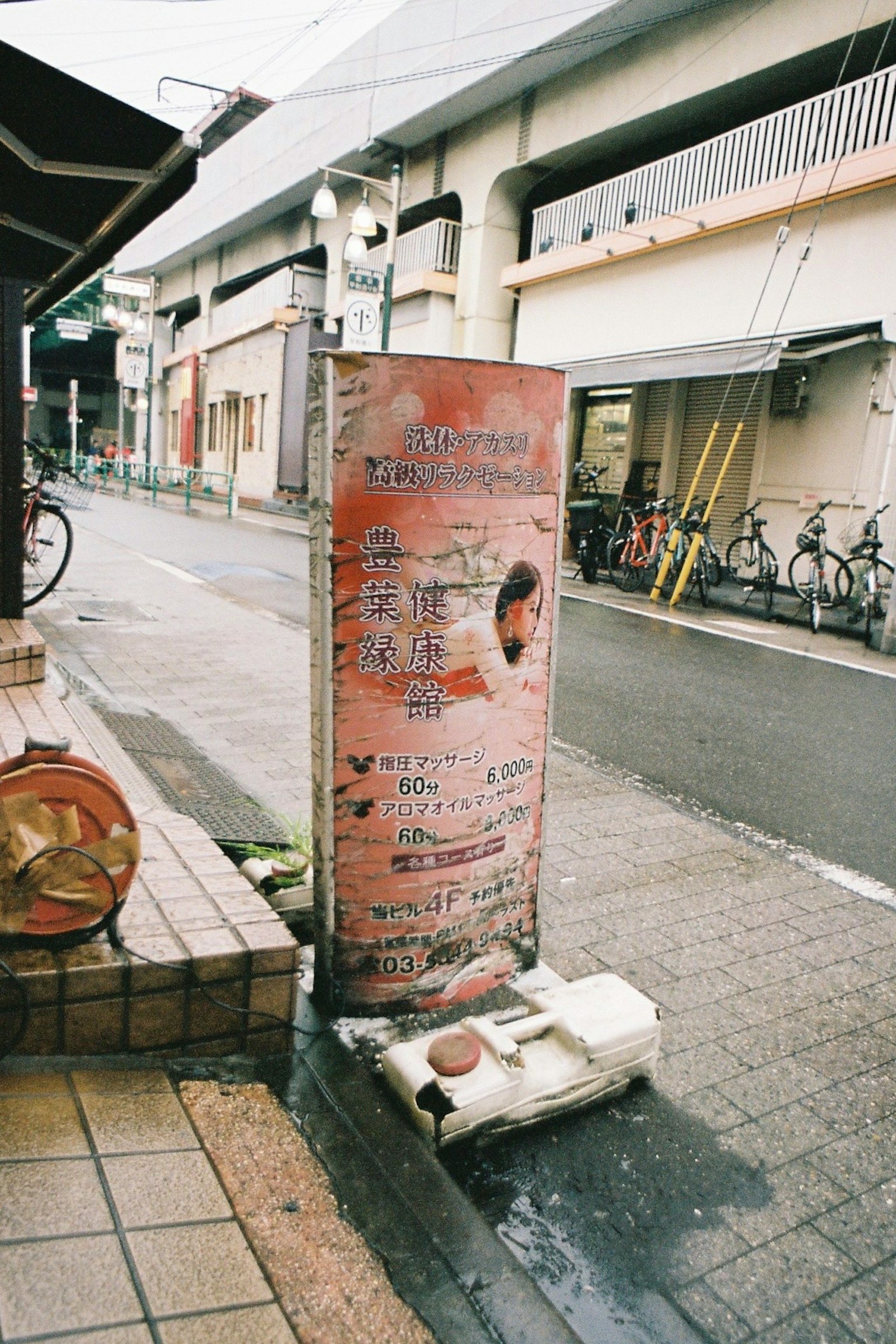 Street corner with an old sign bicycles parked nearby