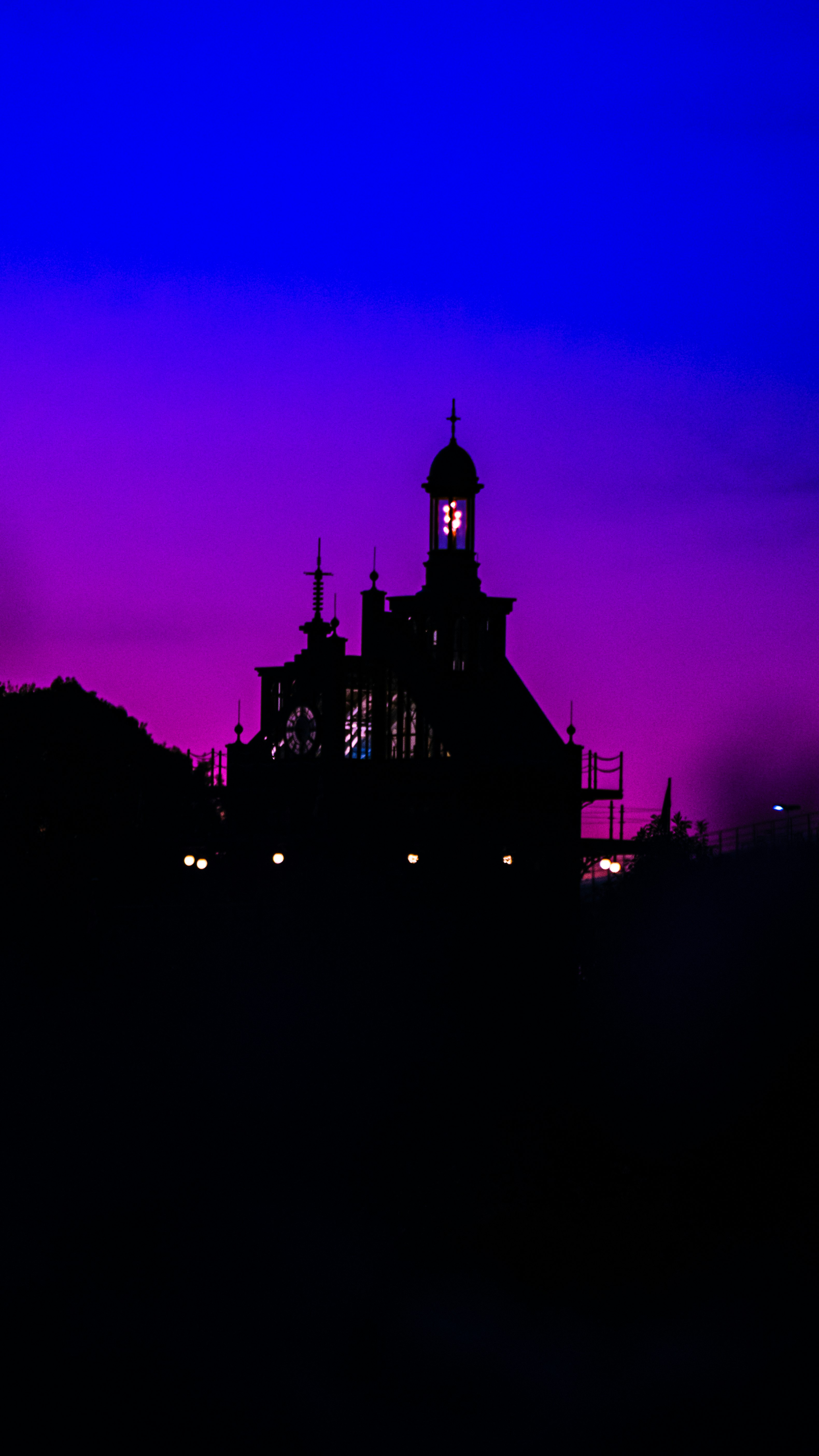 church silhouette at dusk with city lights