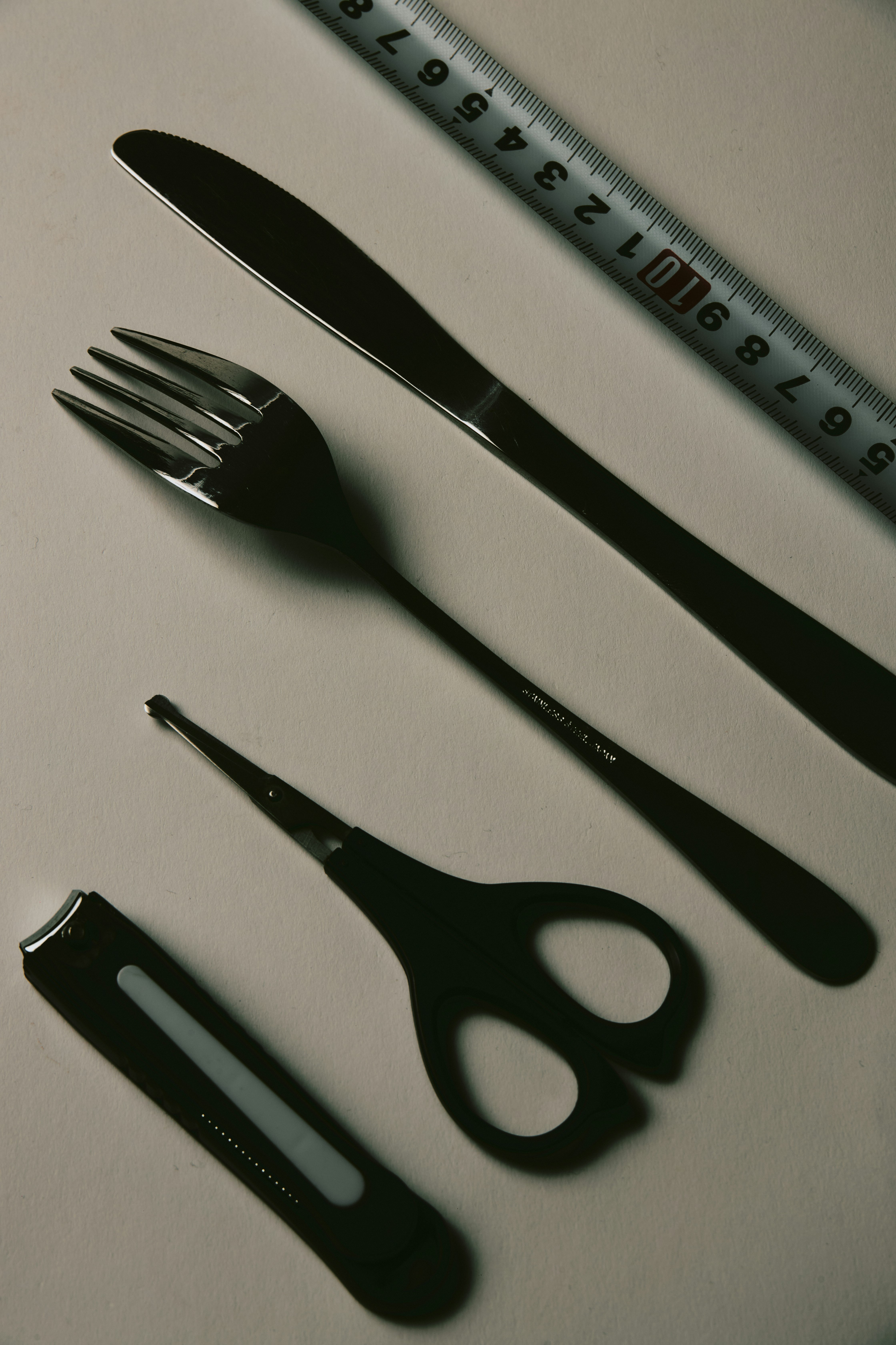 still life of a ruler with cutlery on a tabletop