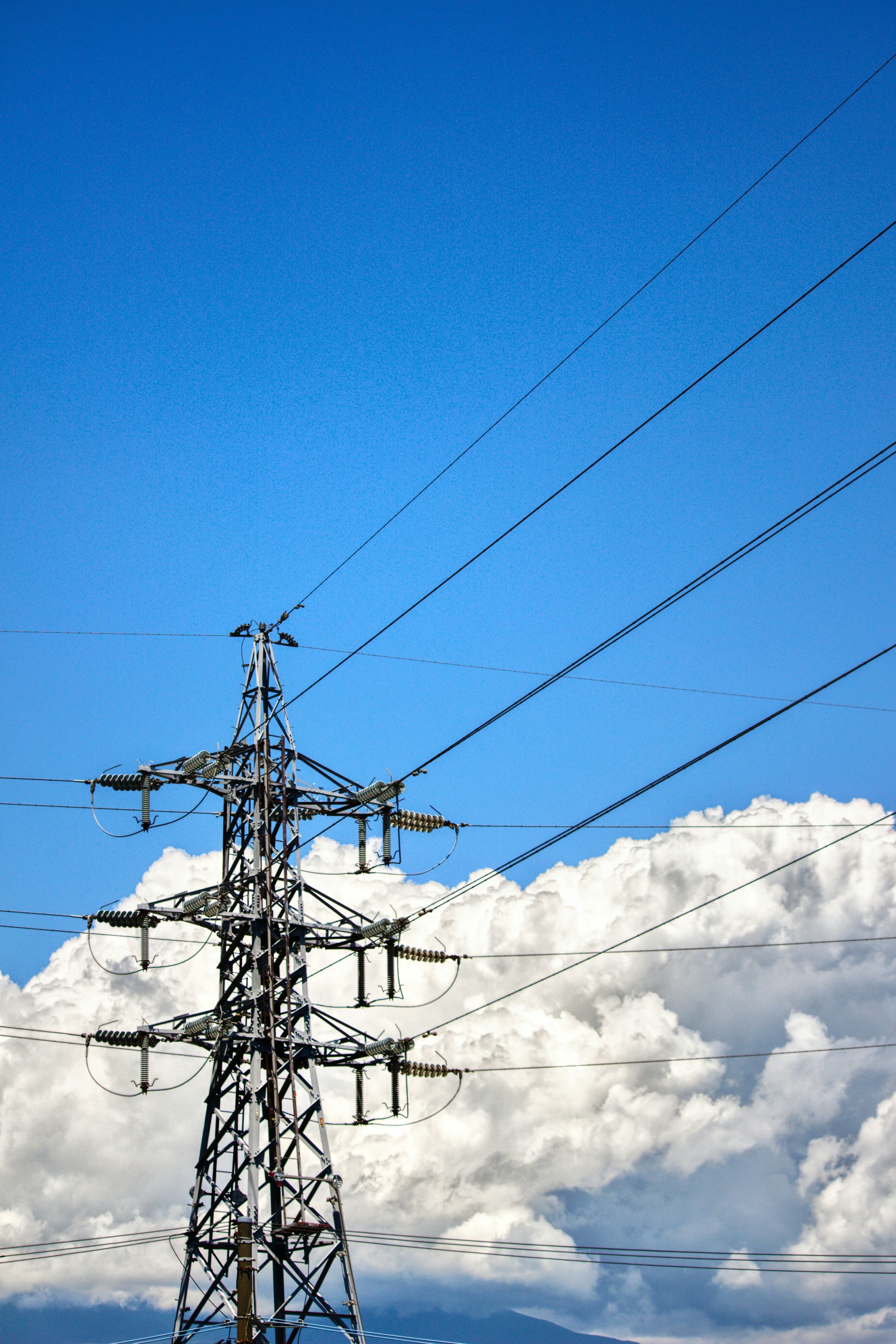 入道雲の下の青空と送電鉄塔