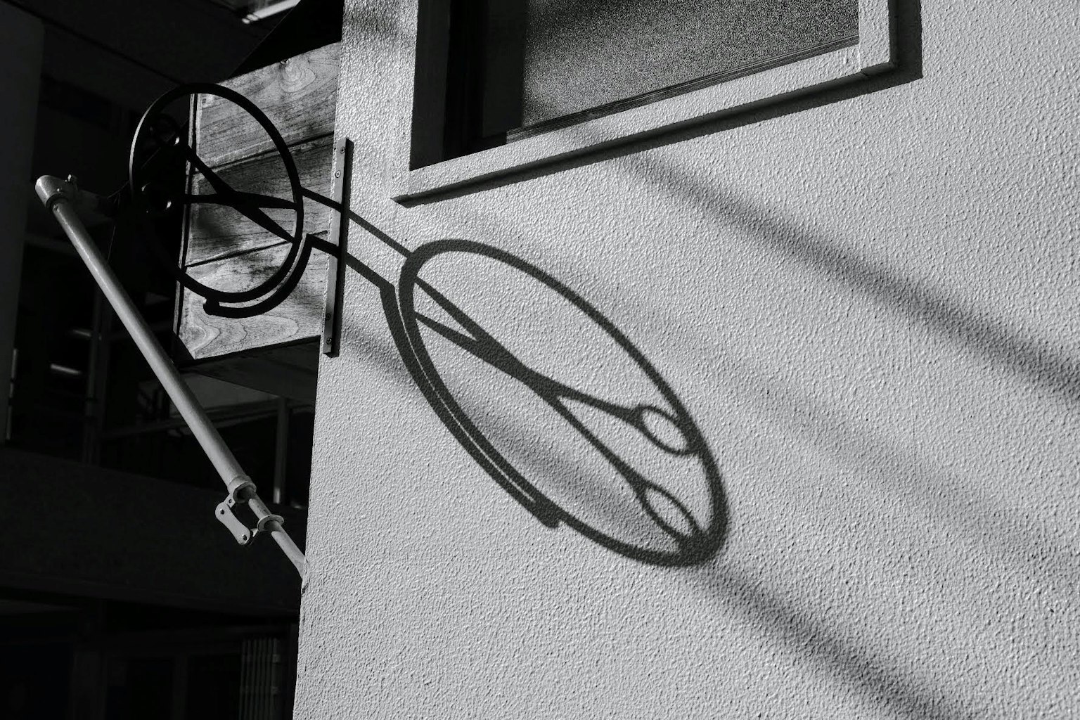 Ombra unica e struttura metallica circolare su un muro bianco e nero