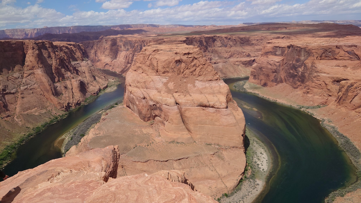 Vue imprenable sur Horseshoe Bend avec des formations rocheuses rouges et une rivière verte