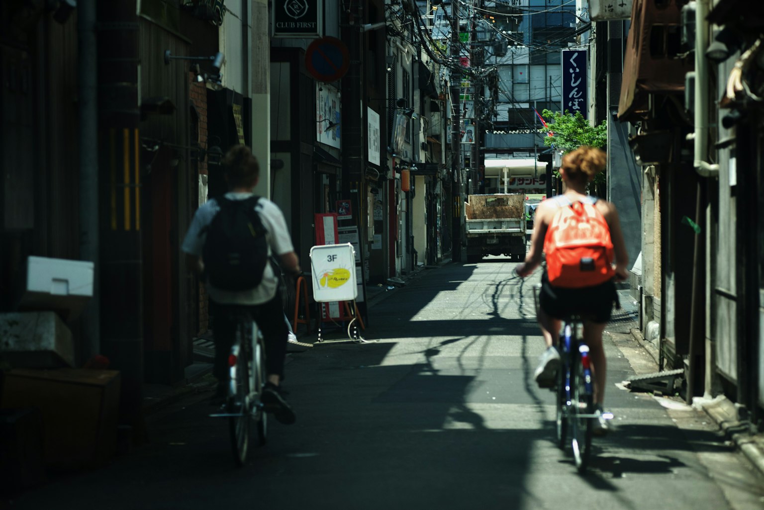 좁은 골목길에서 자전거를 타는 두 사람