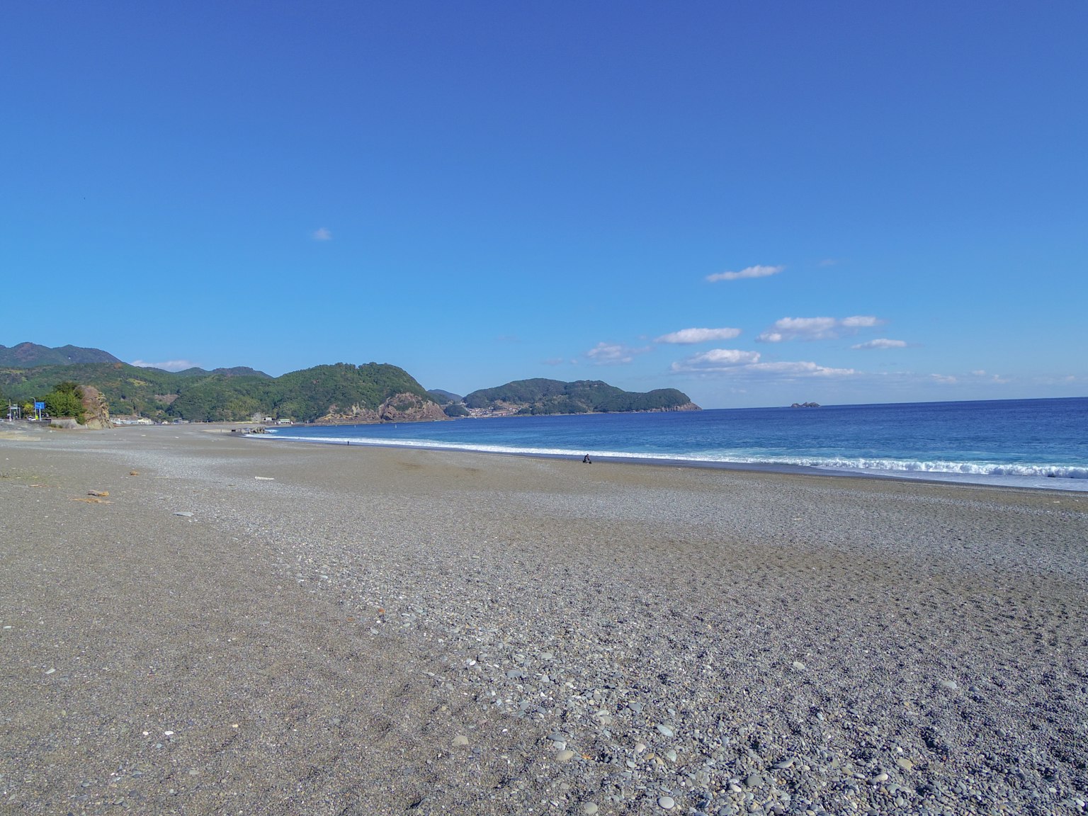 Malersicher Strandblick mit klarem blauen Himmel und ruhigem Meer