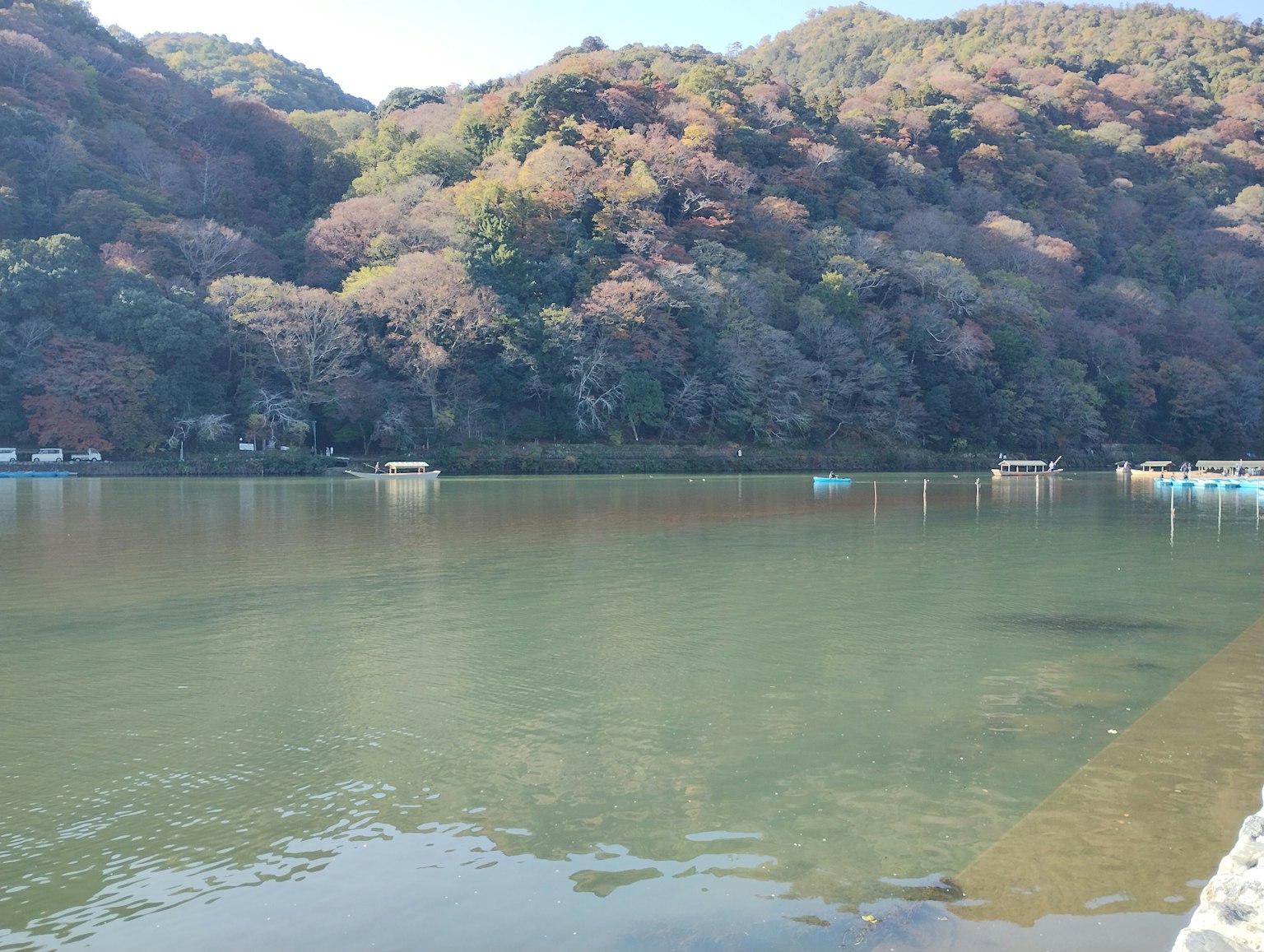Danau tenang dikelilingi oleh dedaunan musim gugur dan perbukitan