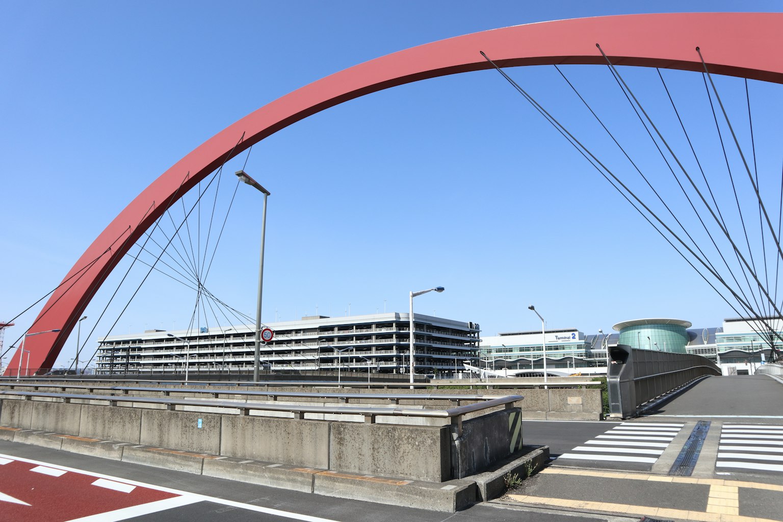 Rote Bogenbrücke mit modernen Gebäuden im Hintergrund