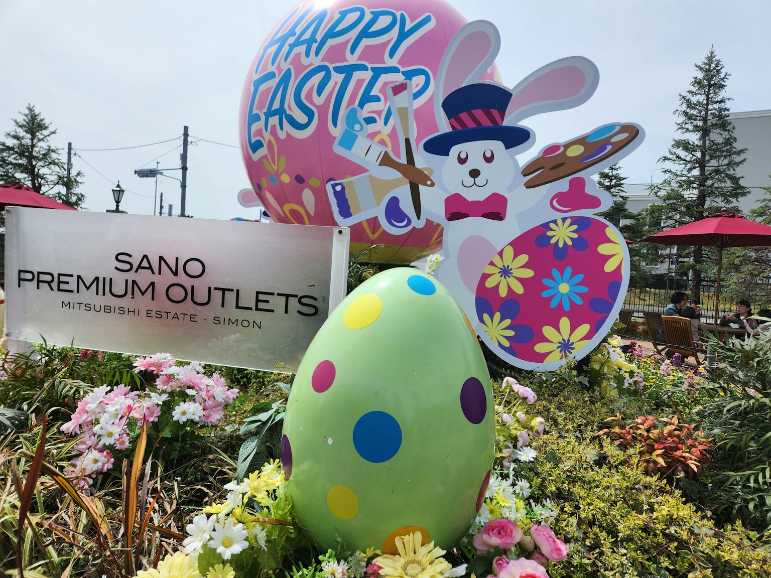 Colorful Easter decorations including a large balloon and a painted egg in a flower garden