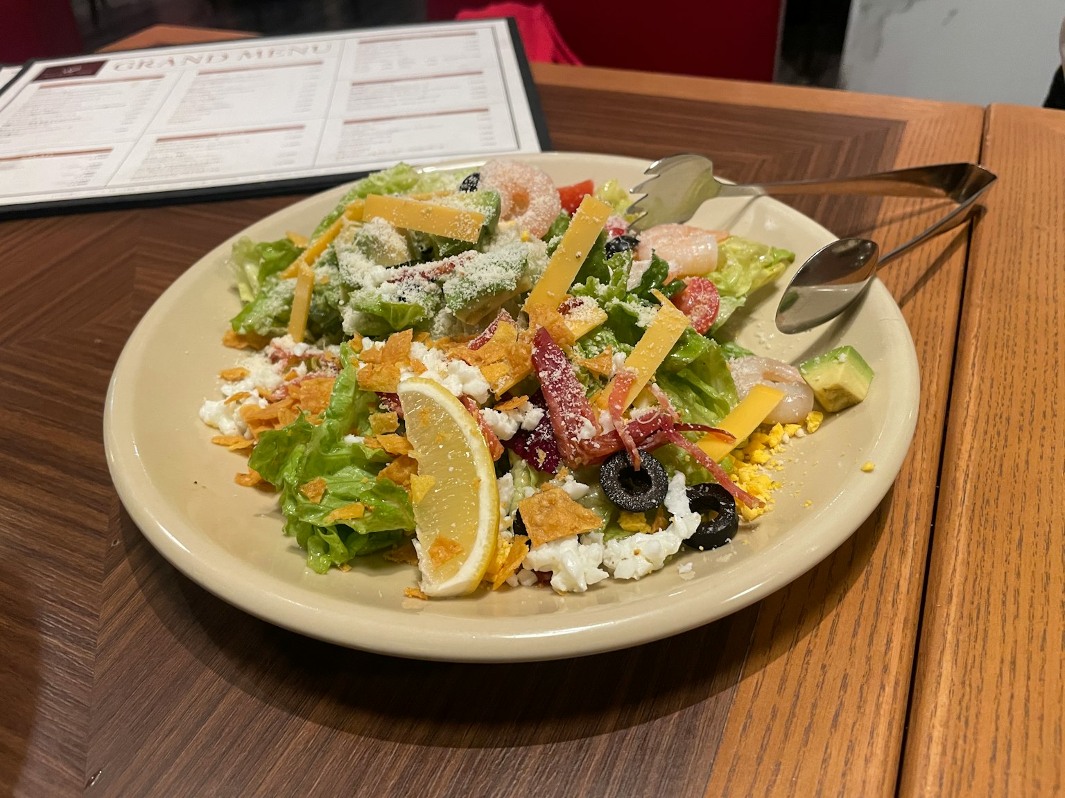 Une assiette de salade fraîche avec de la laitue, des tomates, du fromage et des olives