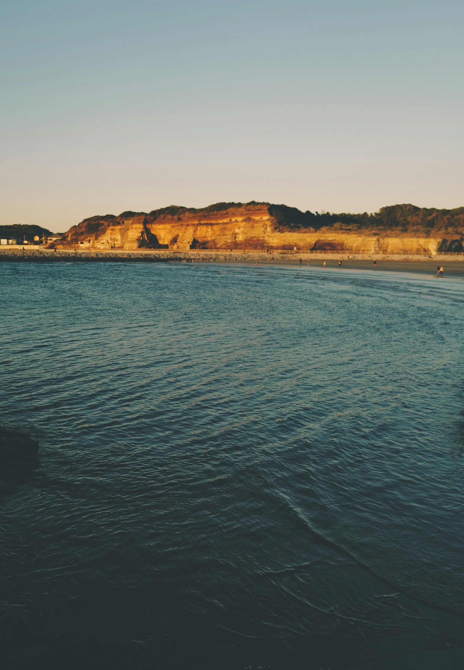 宁静的风景，夕阳下金色悬崖与平静的海水