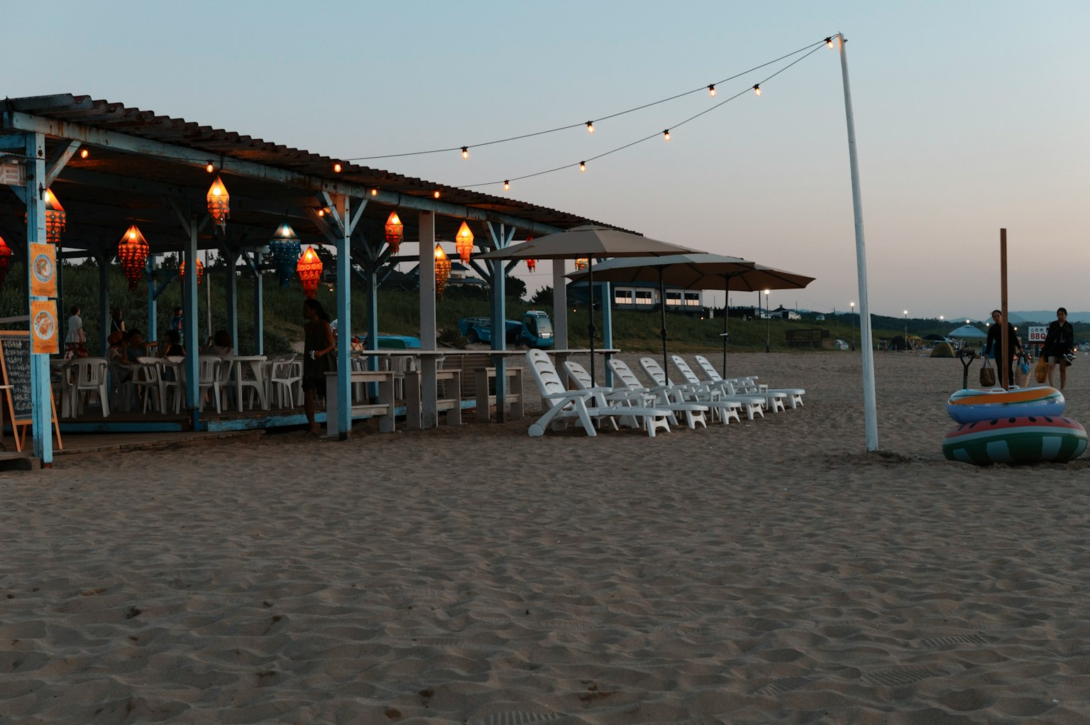 ร้านอาหารริมชายหาดพร้อมเก้าอี้ชายหาดสีขาวบนชายหาด