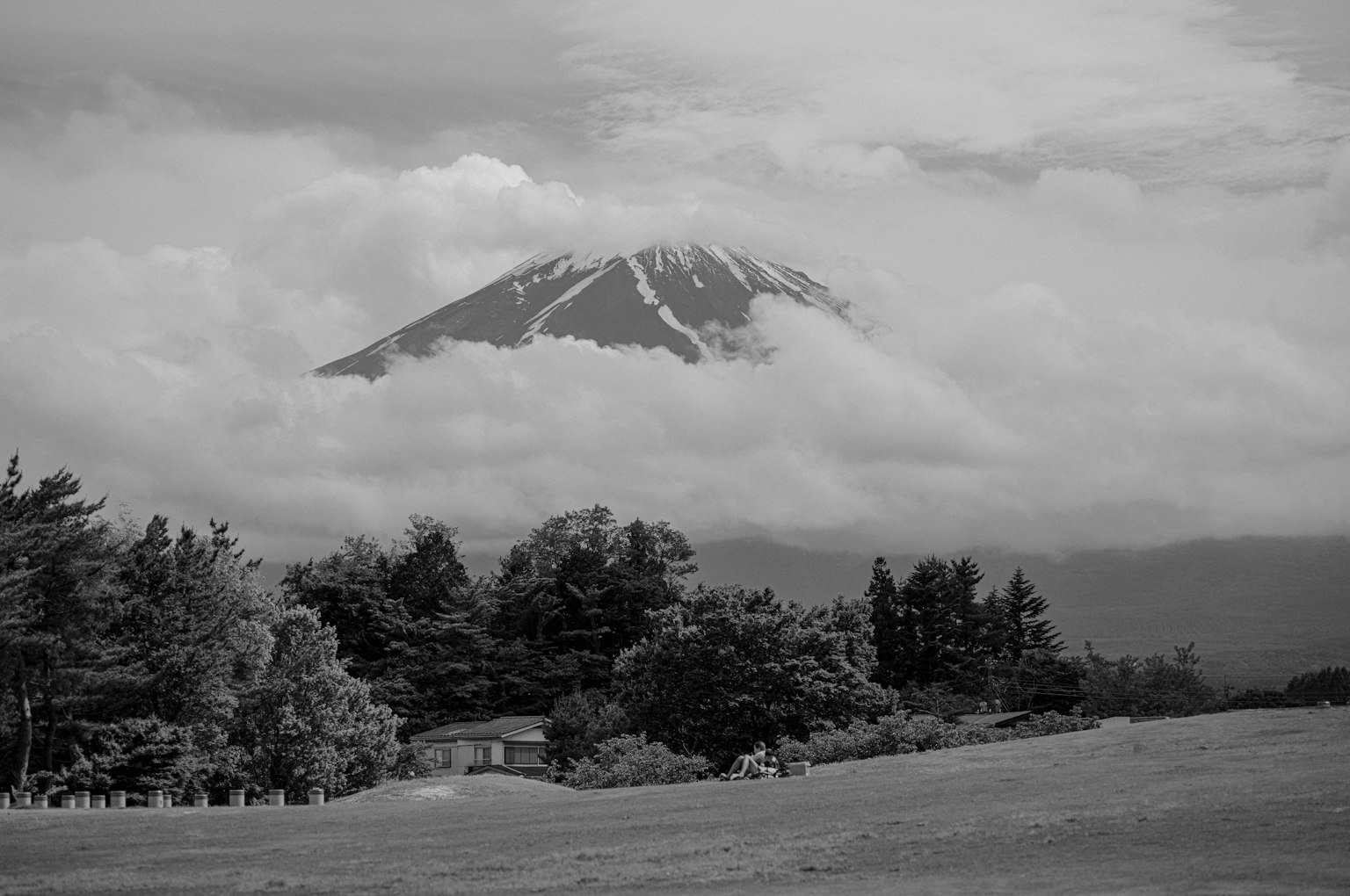 Paisaje en blanco y negro con el monte Fuji parcialmente cubierto por nubes