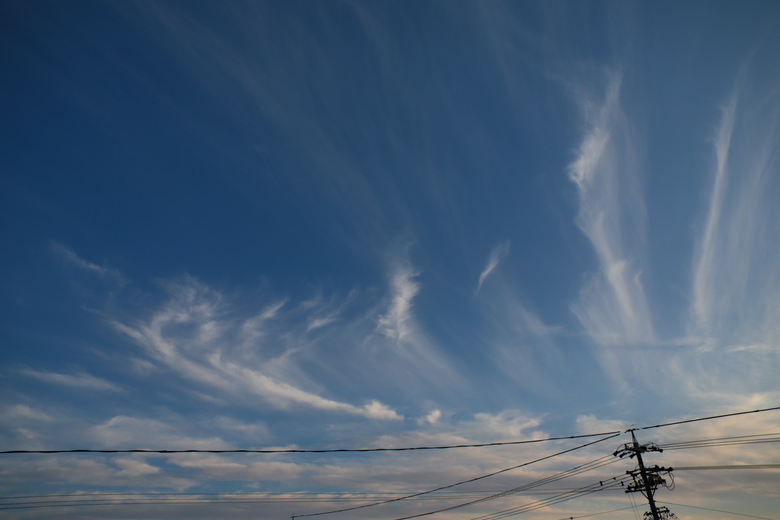 Patrones de nubes en un cielo azul con líneas eléctricas