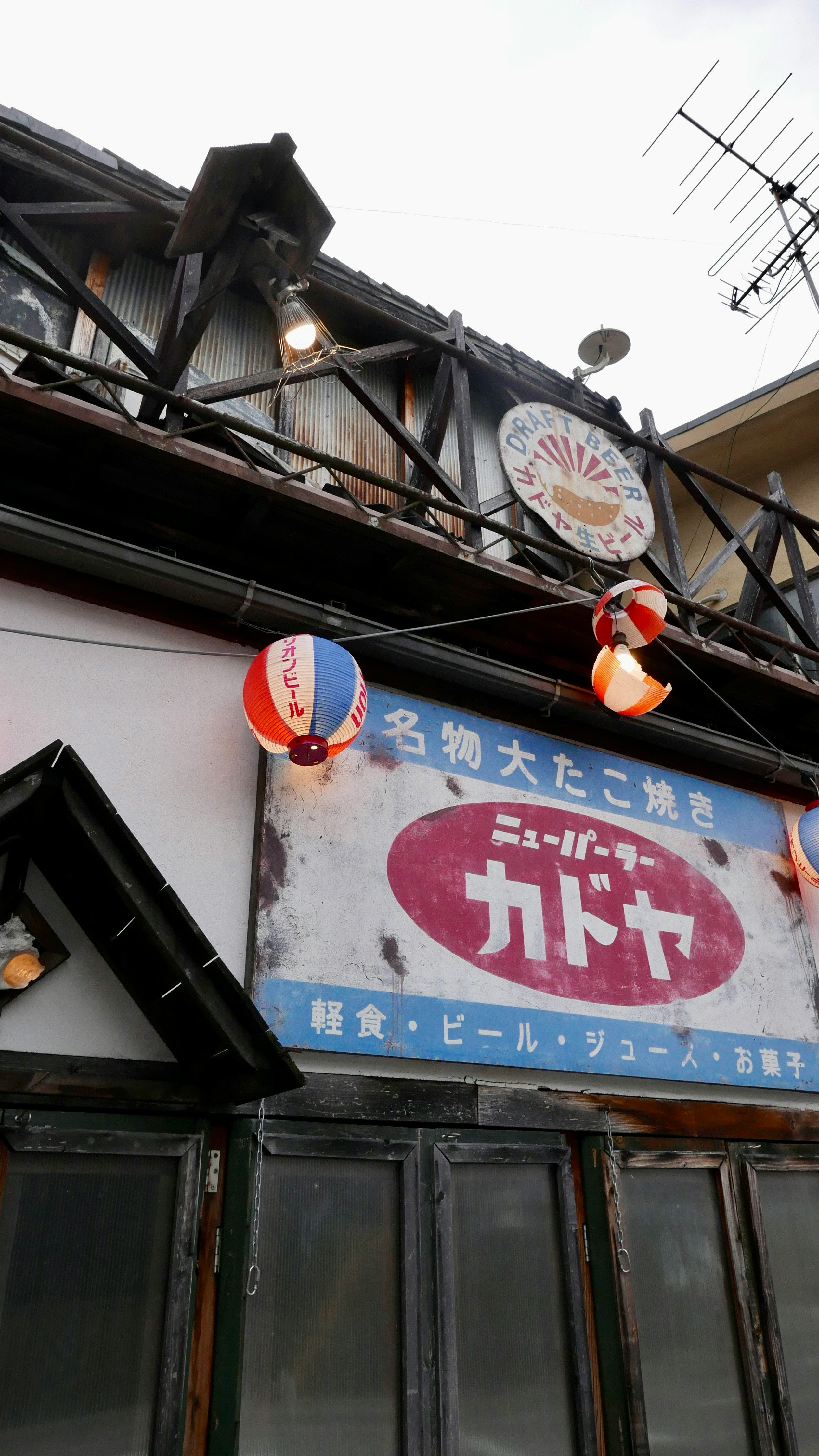看板と提灯が掛かった木造の店先