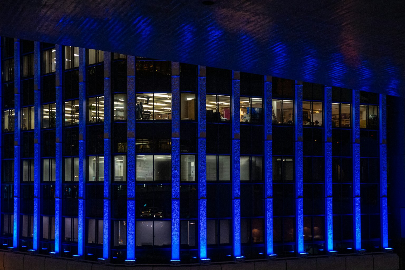 Exterior de un edificio de oficinas resaltado por iluminación azul