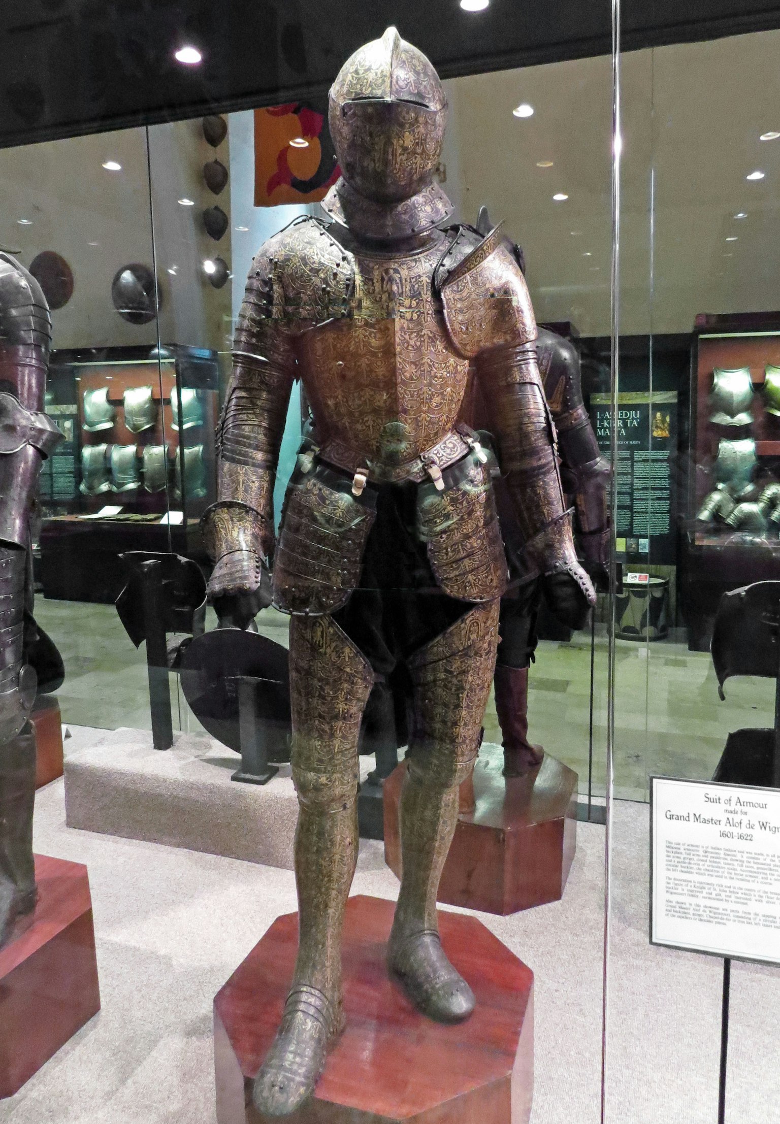 A knight statue wearing medieval armor displayed in a museum interior