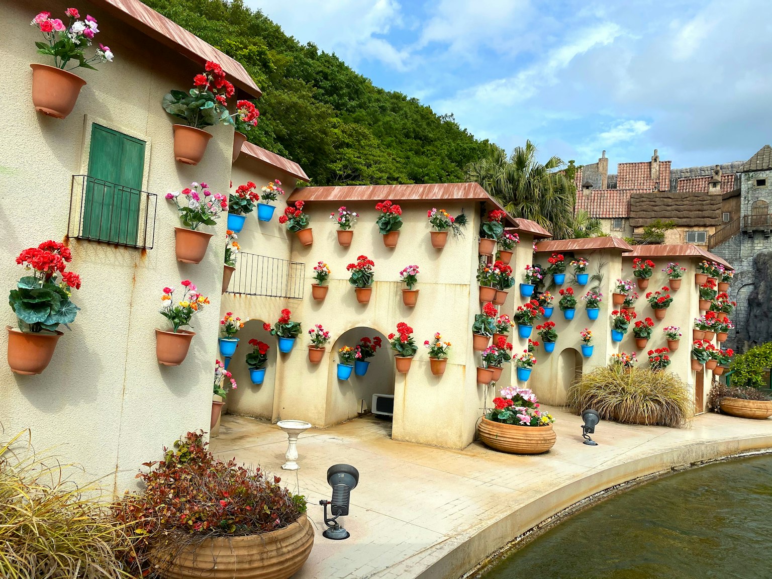 Complejo de edificios únicos adornados con flores coloridas y un estanque