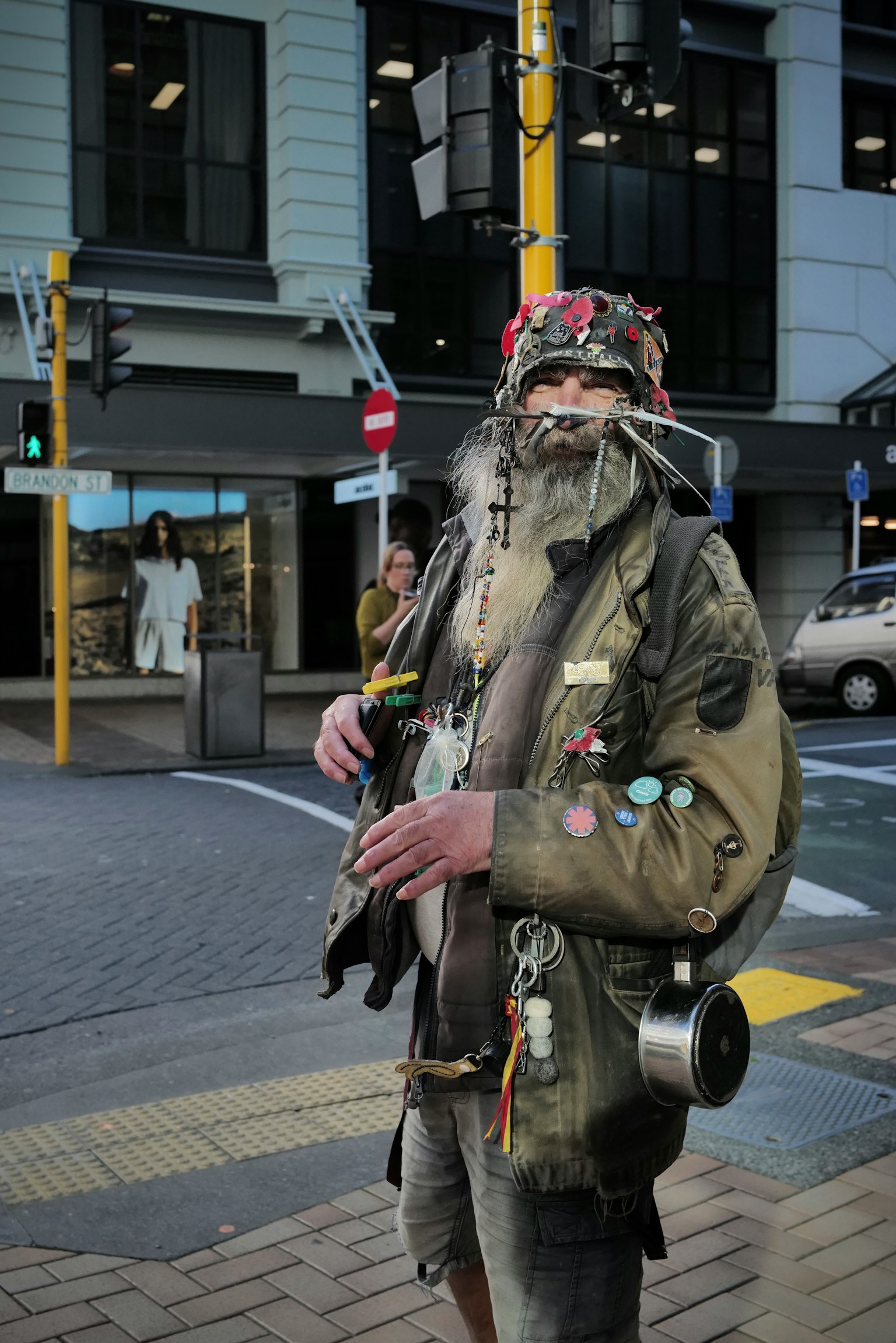 街角に立つ独特な服装の男性 さまざまなバッジや装飾が施されたジャケットを着用
