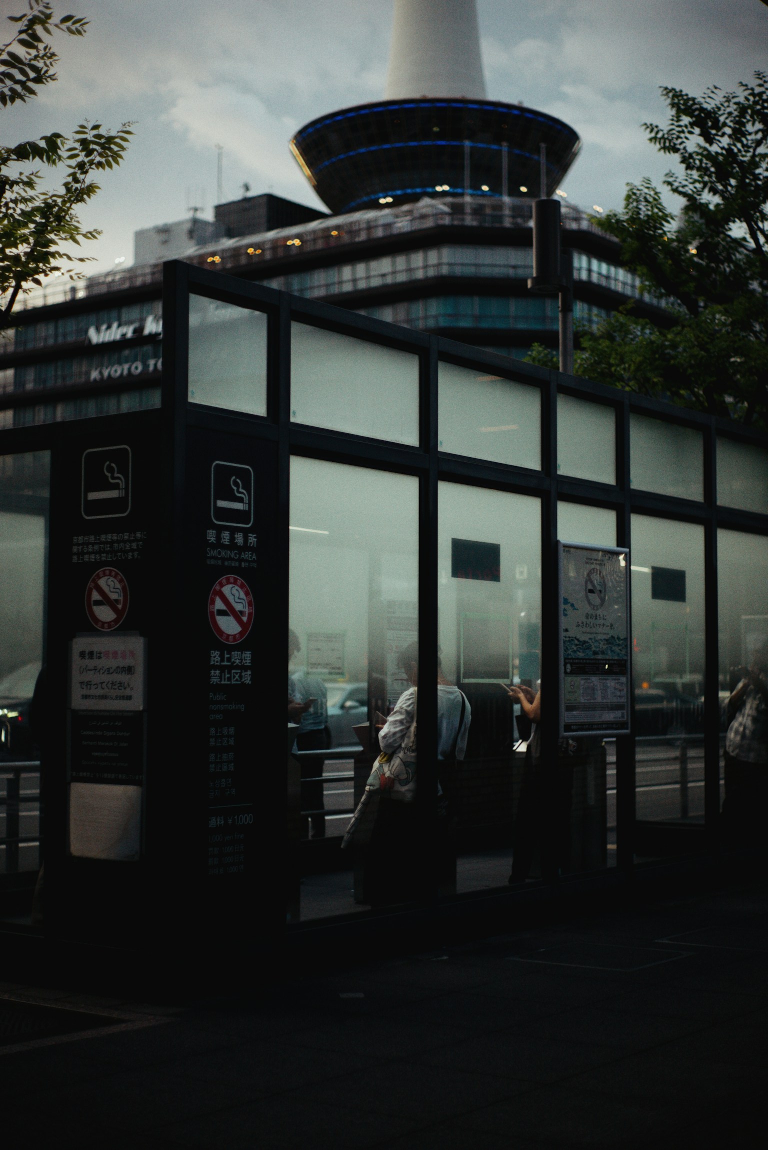 Glasunterstand an einer Bushaltestelle mit einem Gebäude im Hintergrund