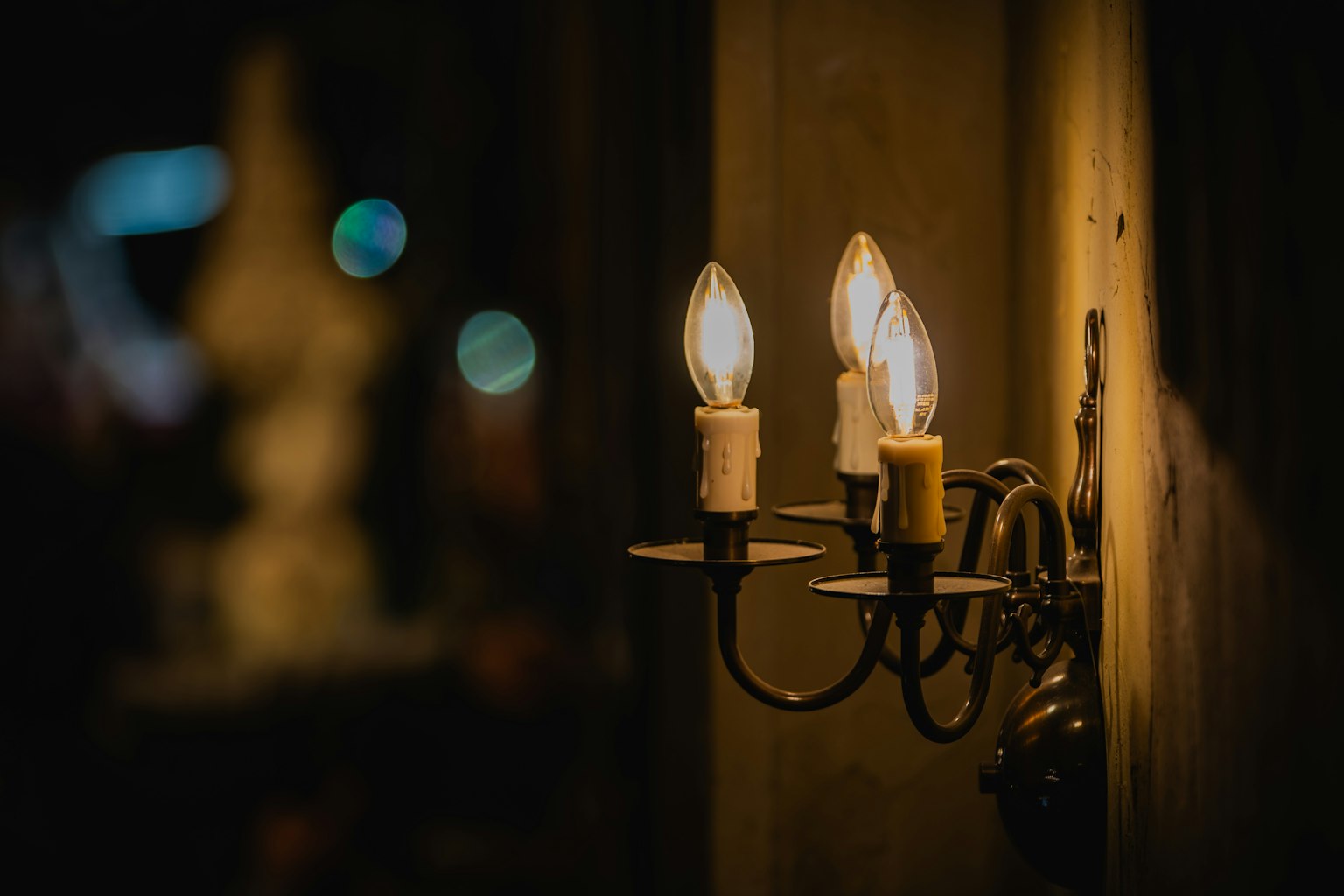 Tre luci a forma di candela montate su un muro