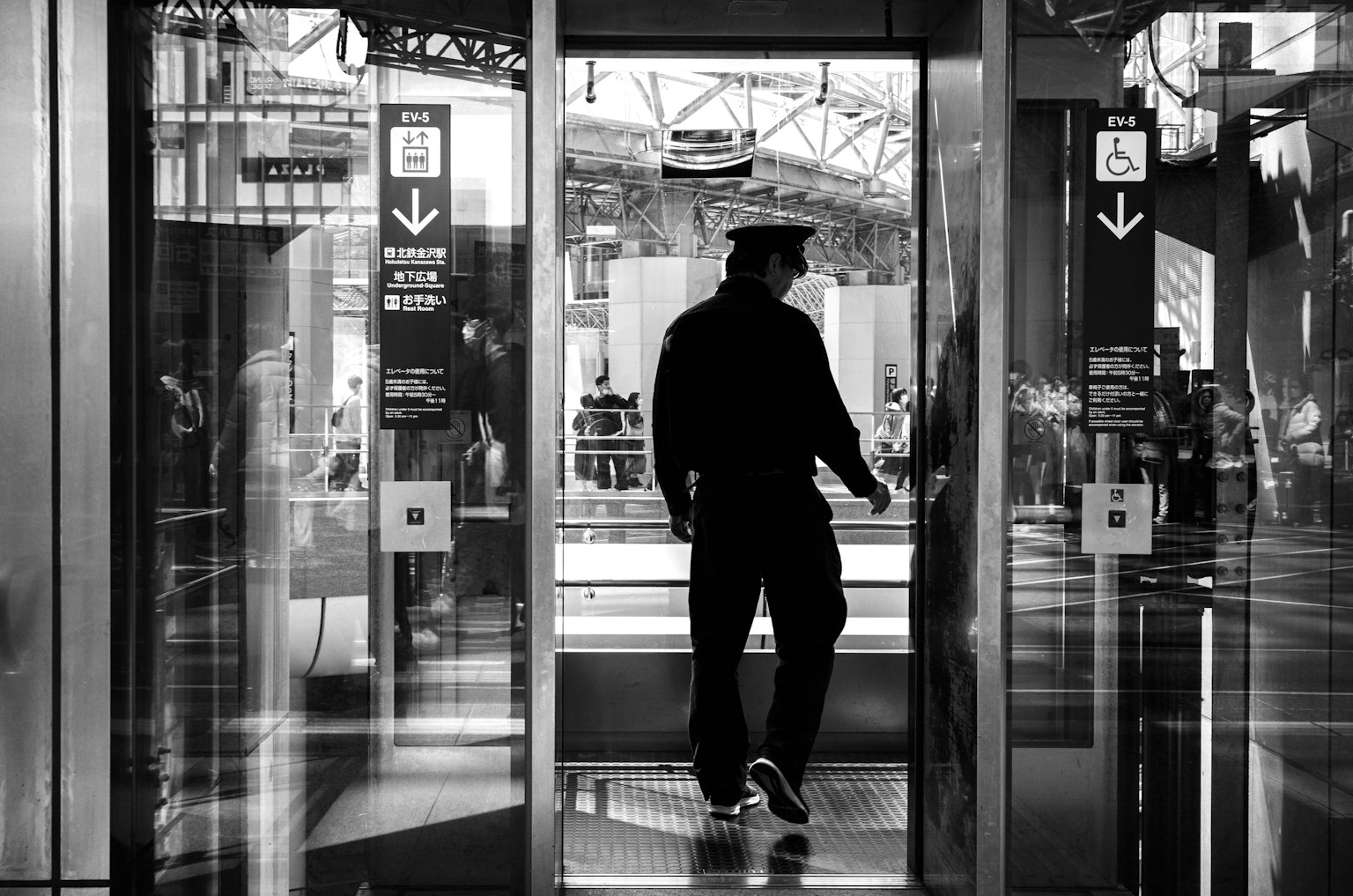 Un homme en vêtements noirs sortant d'un ascenseur