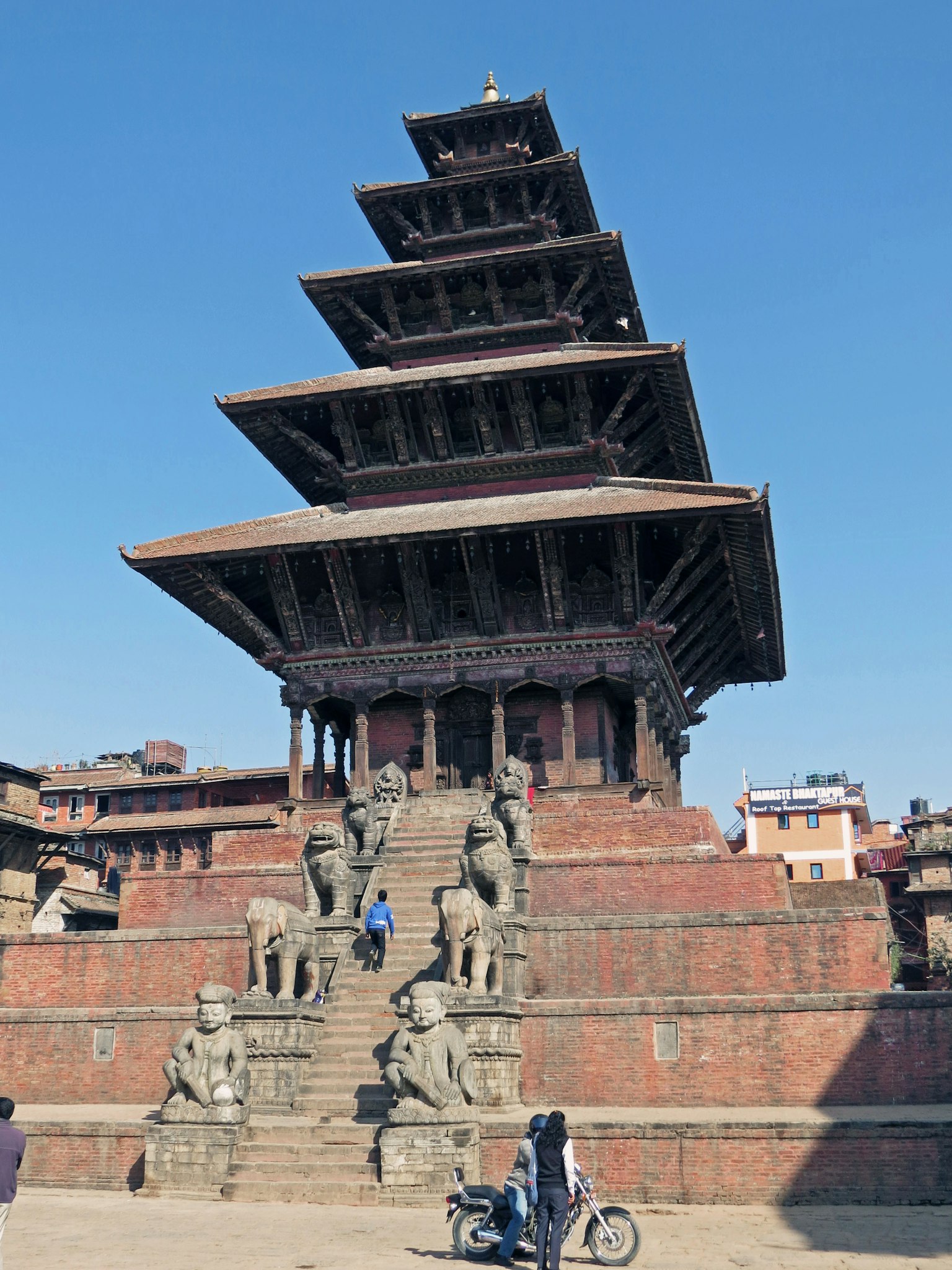 Arsitektur pagoda lima tingkat dengan patung singa batu di Kathmandu Durbar Square