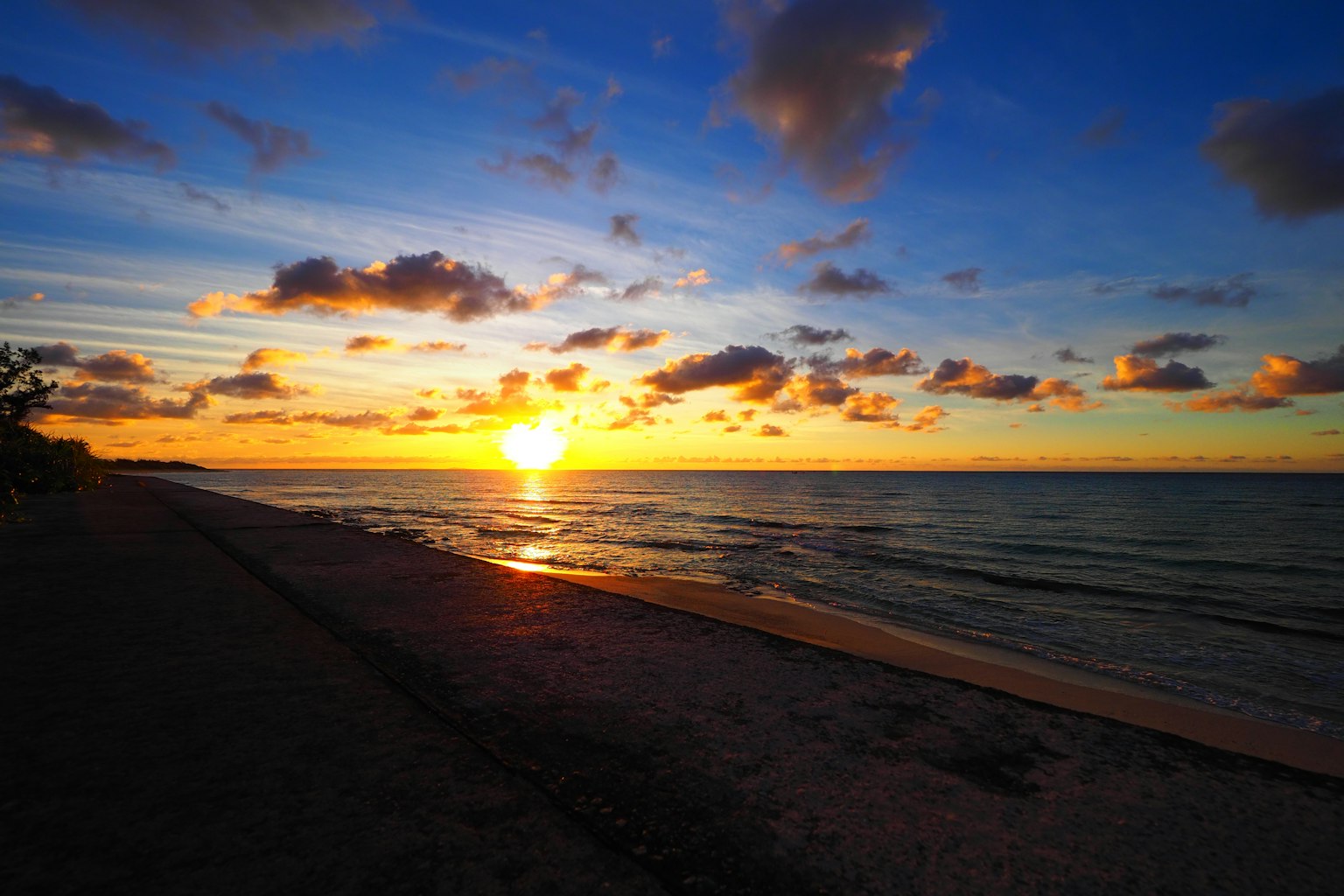 Hermoso atardecer sobre el océano con nubes coloridas y una playa de arena