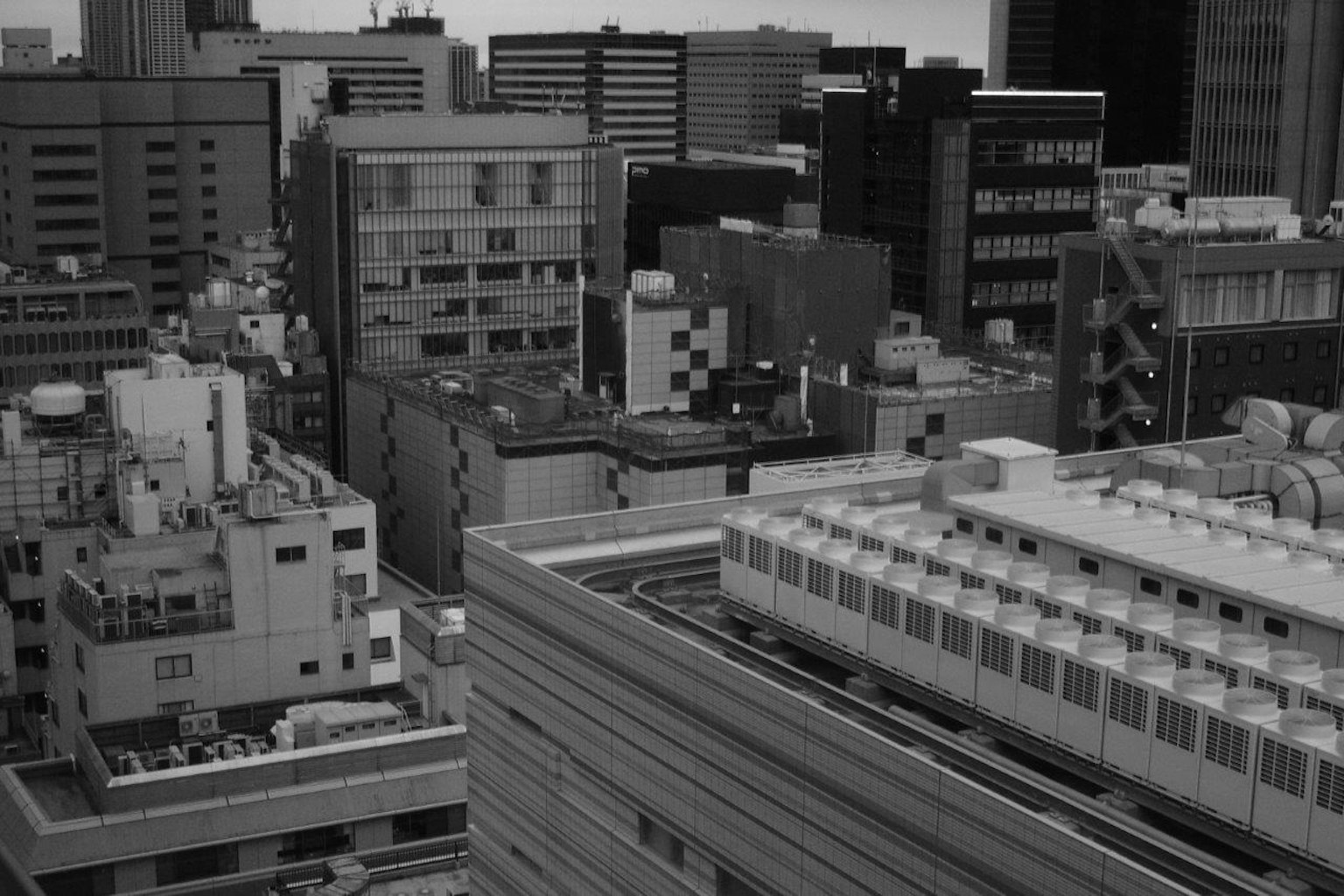 Paisaje urbano en blanco y negro con rascacielos y estructuras en techos