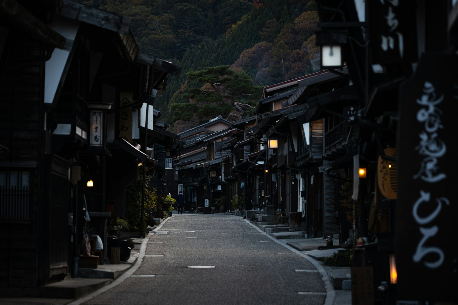 Quiet street surrounded by dark buildings and traditional Japanese architecture