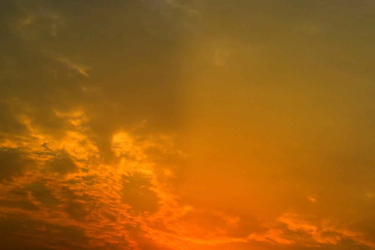 朝焼けの雲間に広がる薄明光線の空