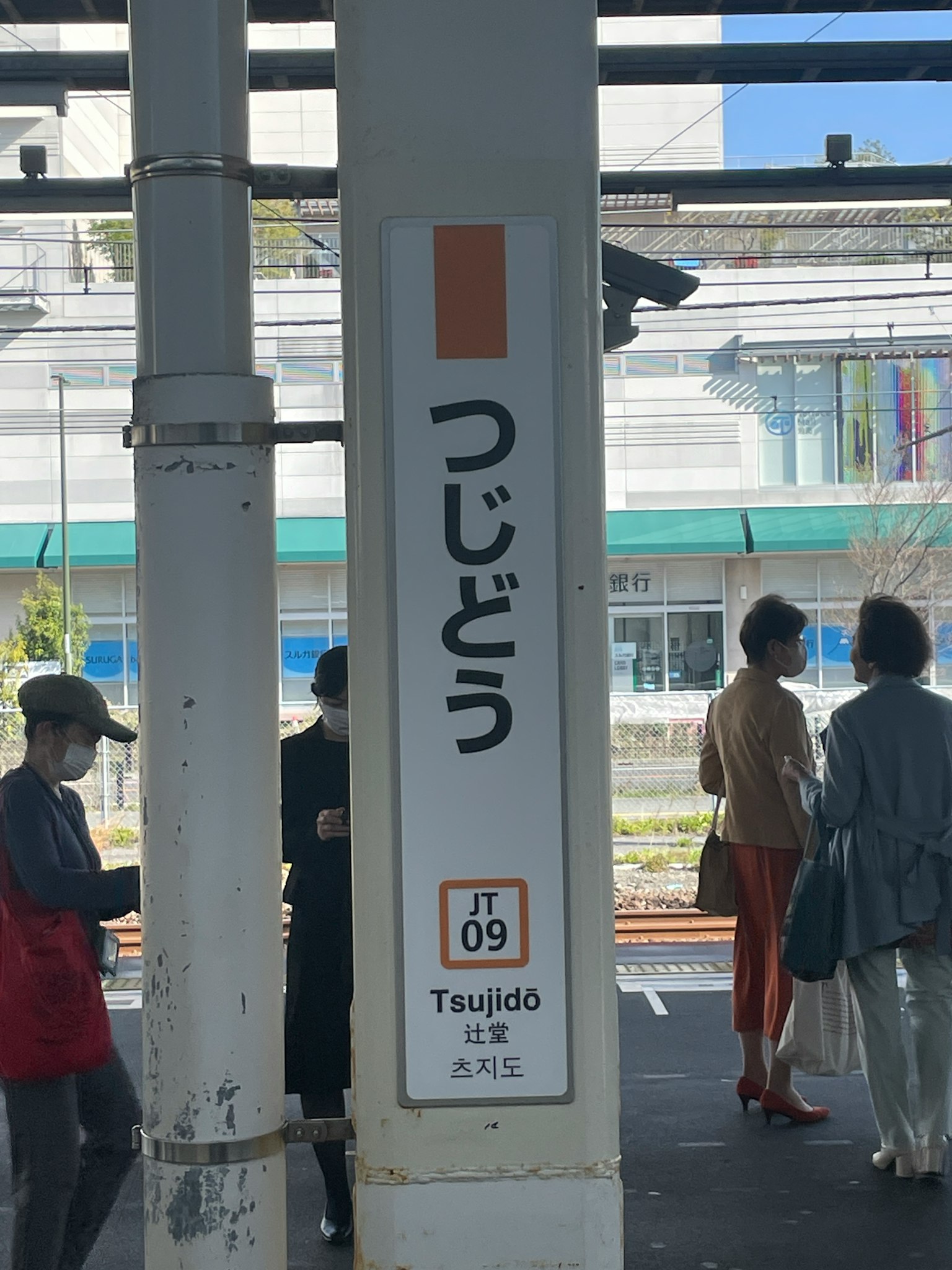 Mọi người tụ tập gần biển báo ga có chữ Tsujido